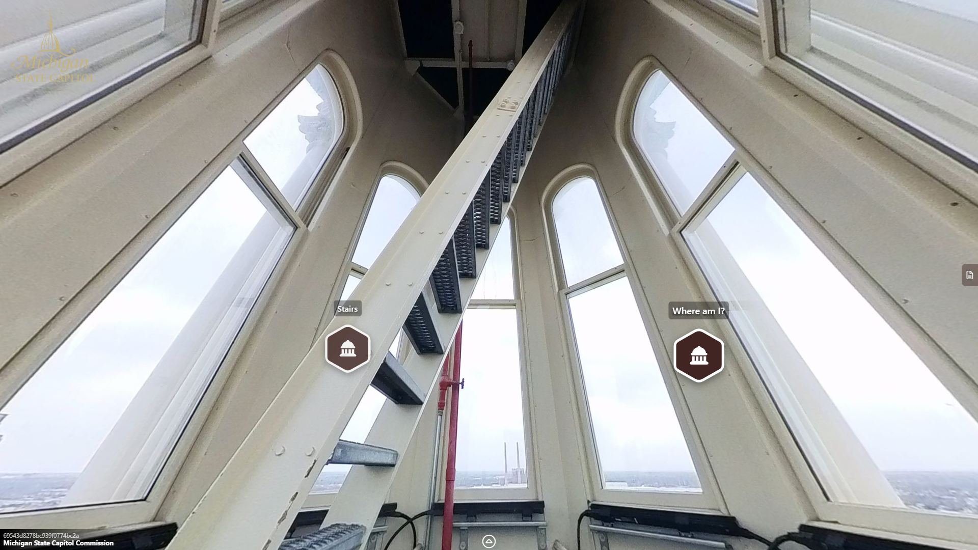 a narrow room with angled walls and windows showing a city skyline. A ladder in the middle of the room leads upward toward a metal platform.