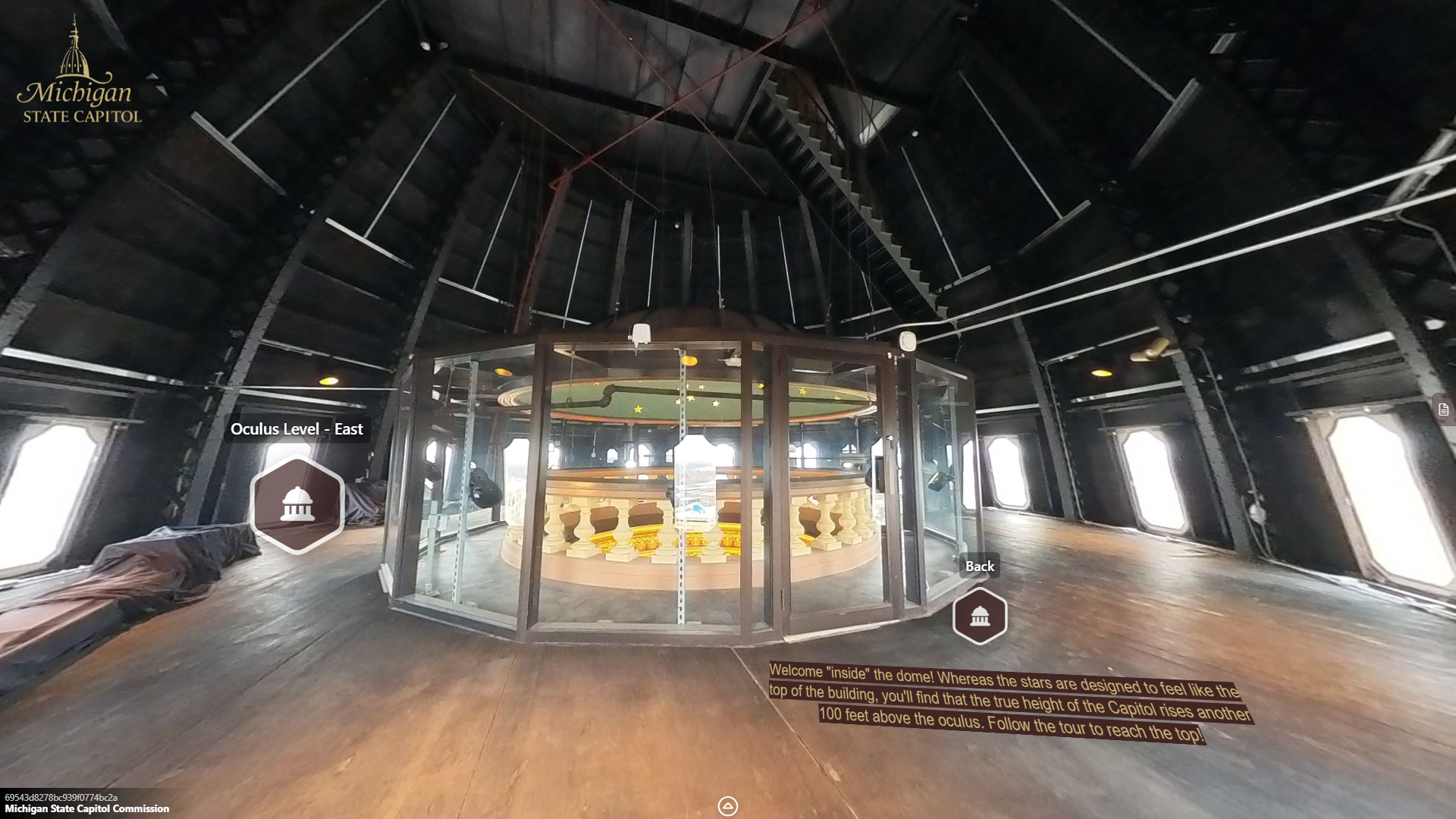 image of a large open space with windows inside of the dome with large black metal trusses extending upwards, a staircase rising int he middle of the space toward the ceiling, and a glass enclosure encircling the oculus railing.