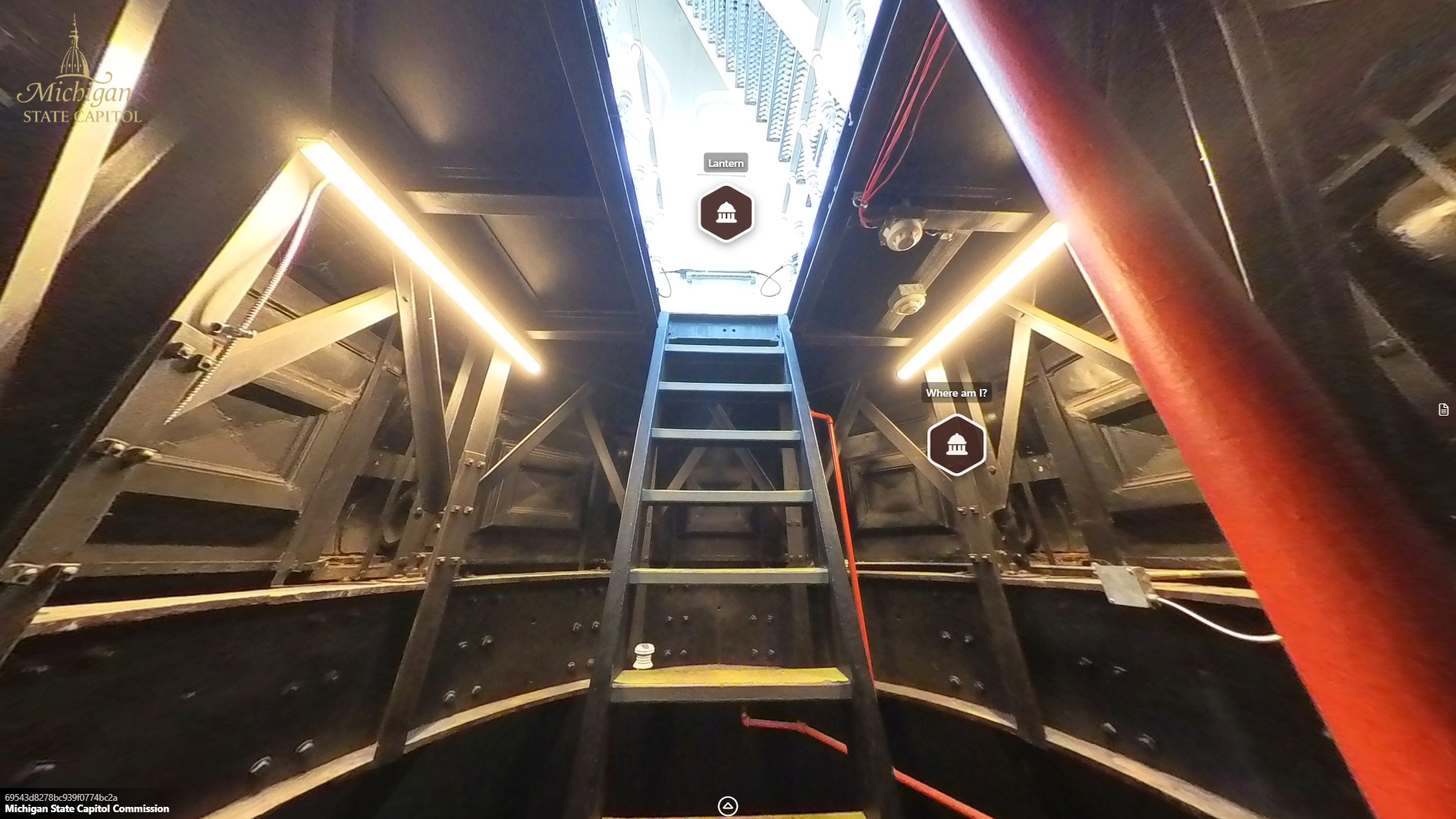 image from inside a narrow metal circular opening, with a metal ladder or stair leading upwards into a brightly lit room and another stairway.