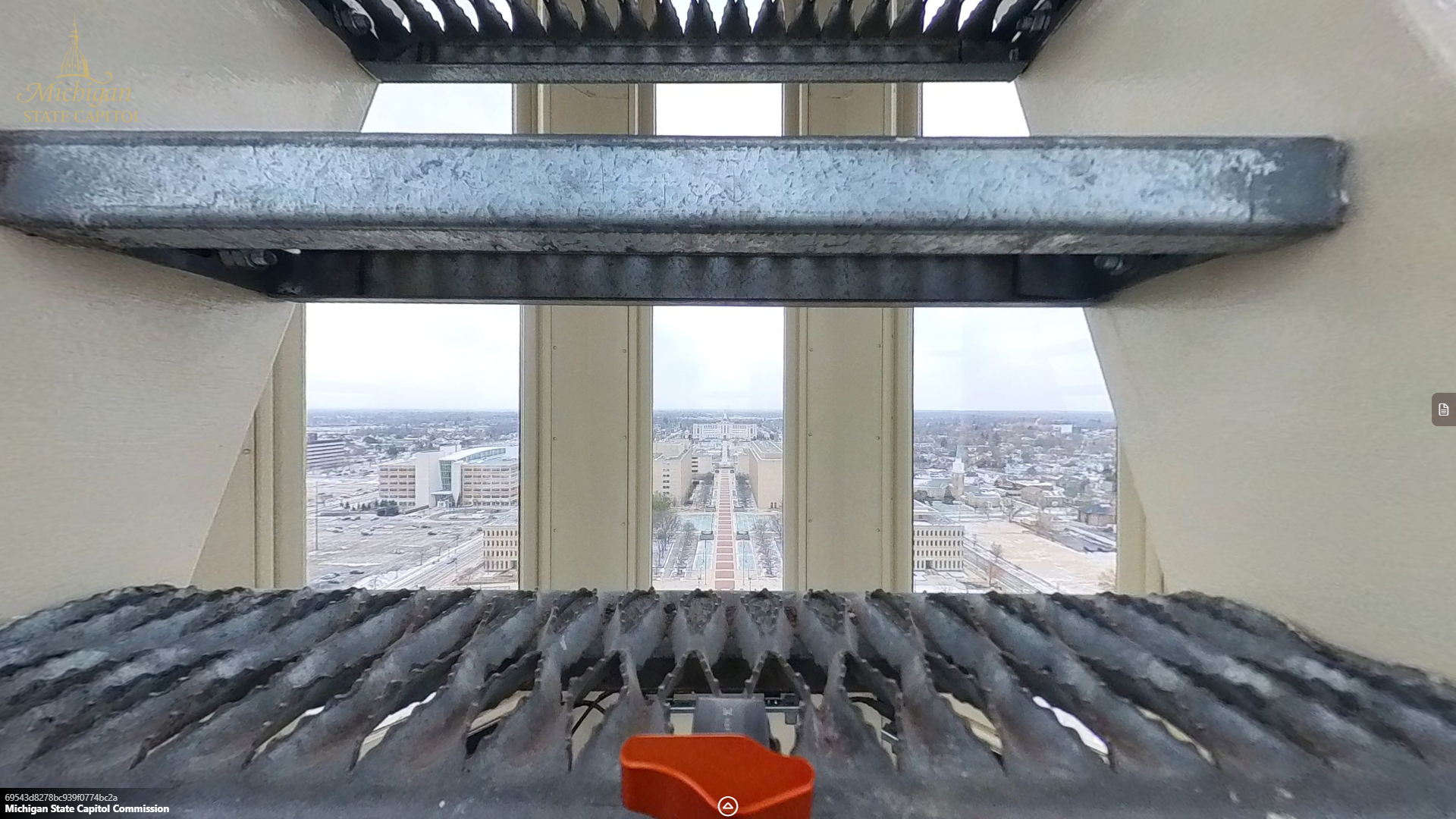 view through the metal steps of a ladder or staircase showing a city skyline through a set of tall windows.
