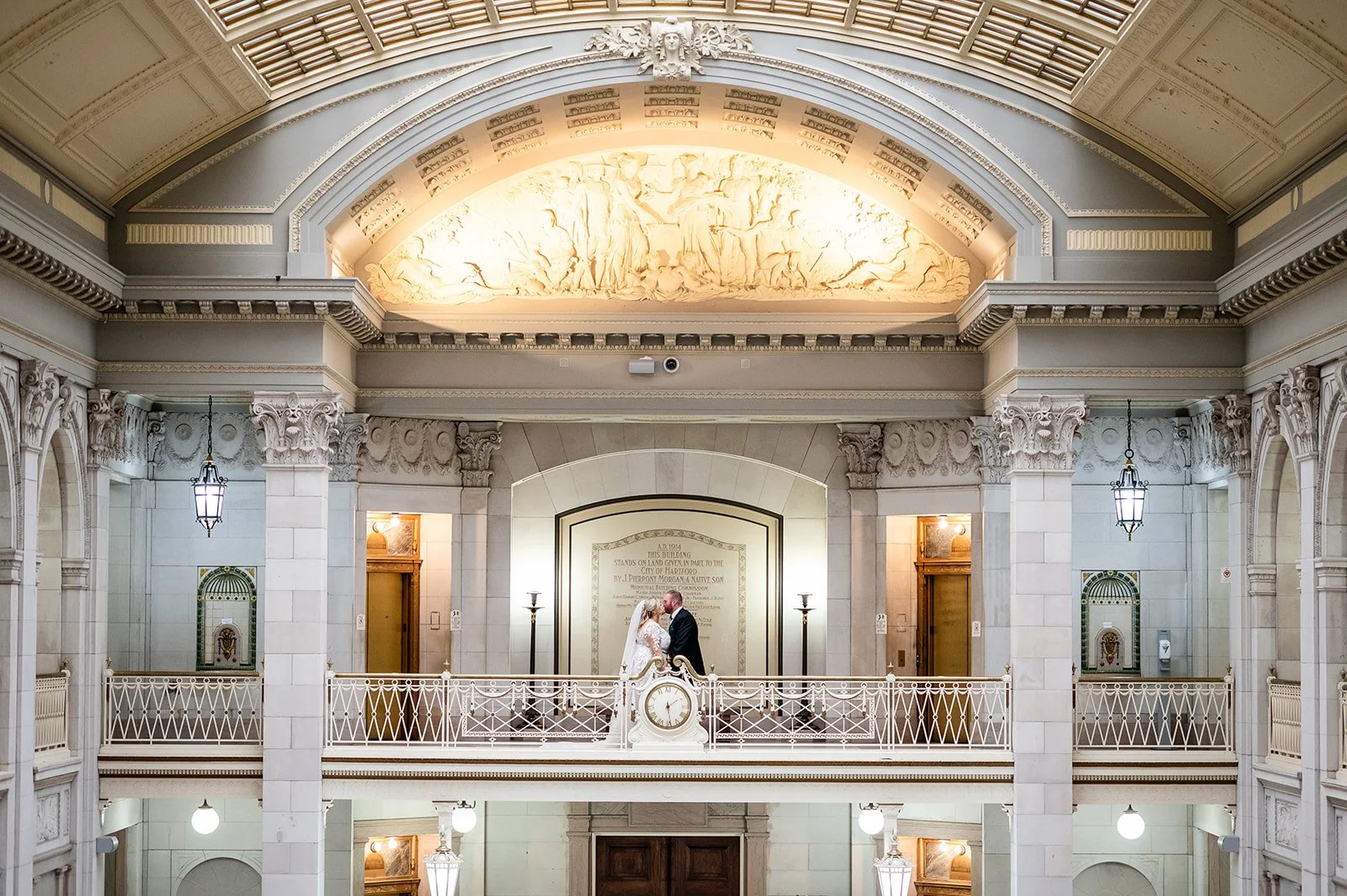 Woman and Man Kissing in an old building with marble walls wearing wedding attire
