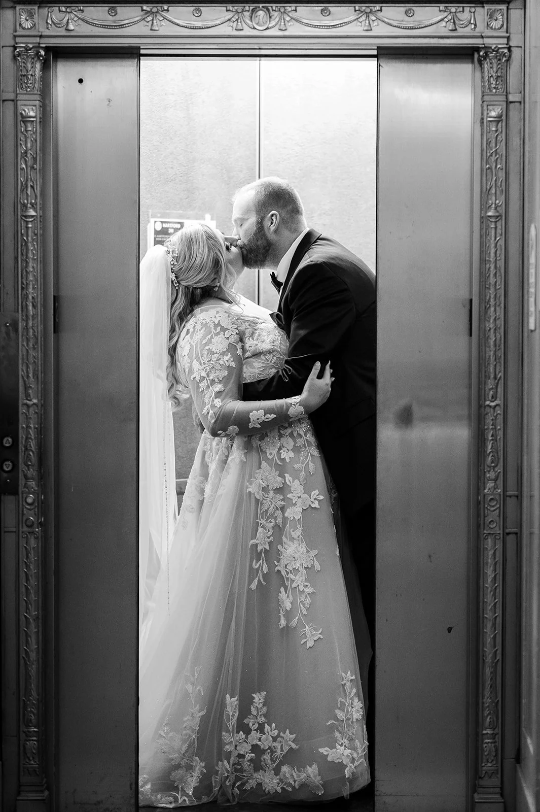 woman and man kissing while elevator door is closing