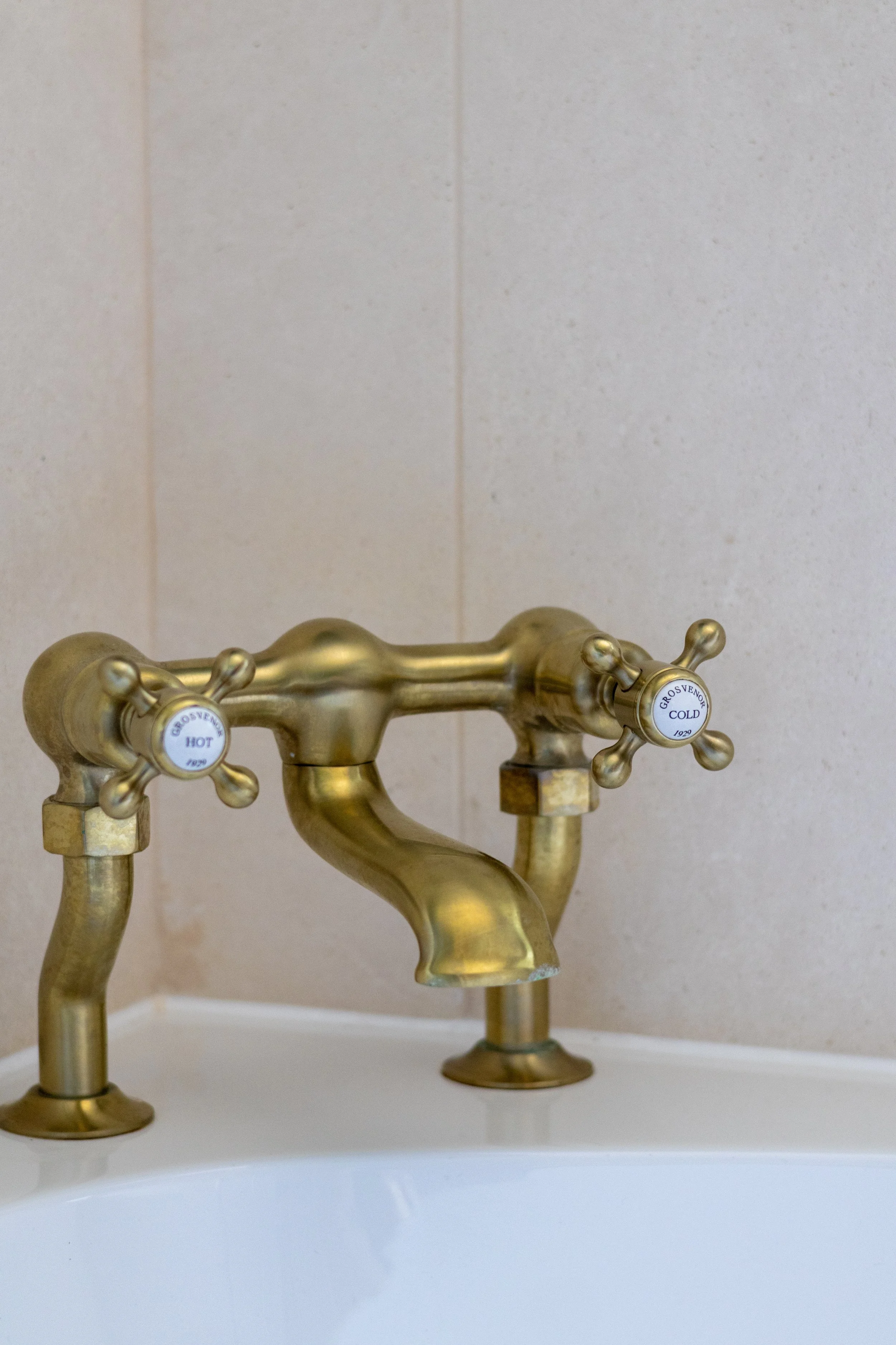 Close-up of vintage-style brass hot and cold cross-head bath taps