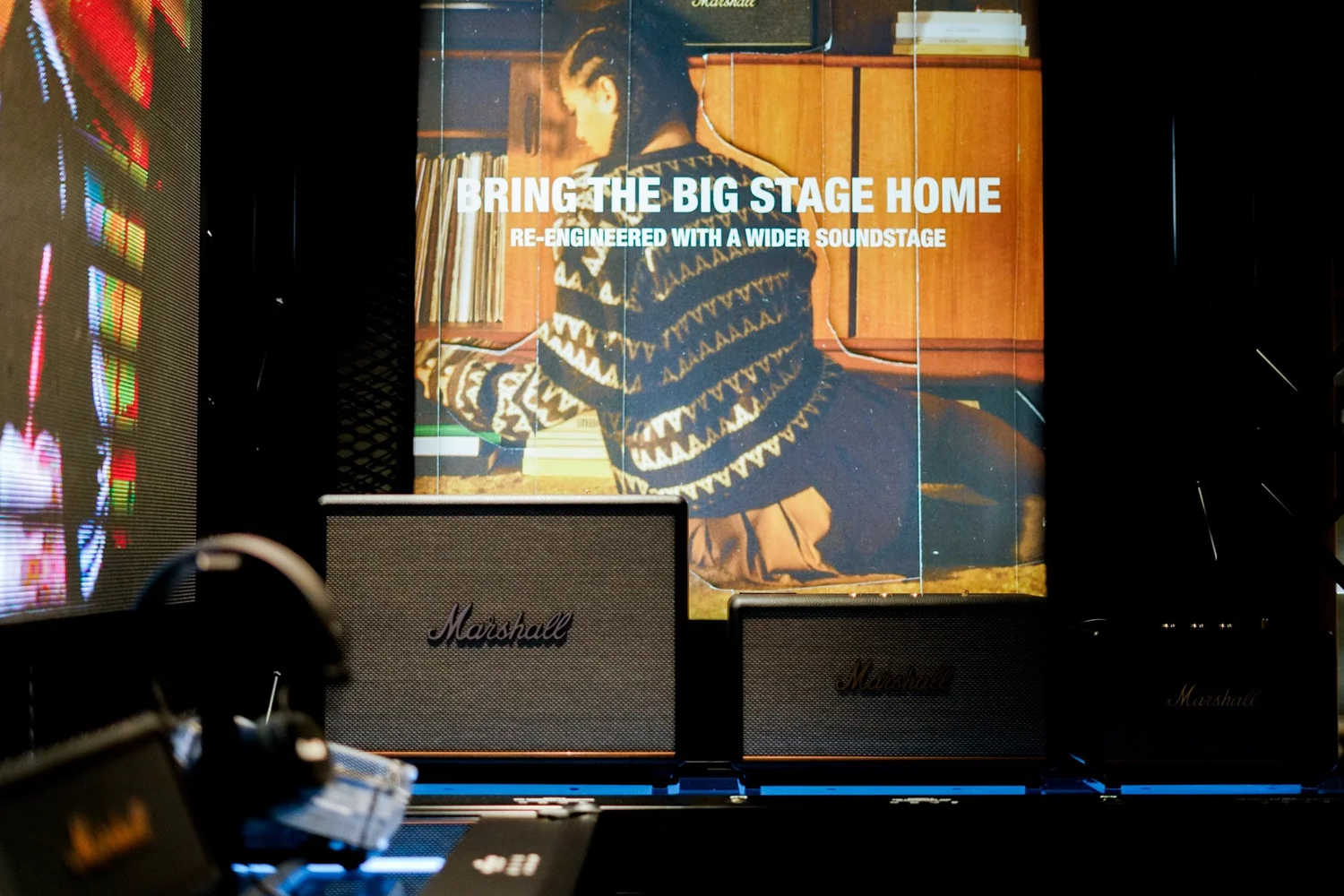 Marshall speakers in front of a “Bring the big stage home” campaign visual