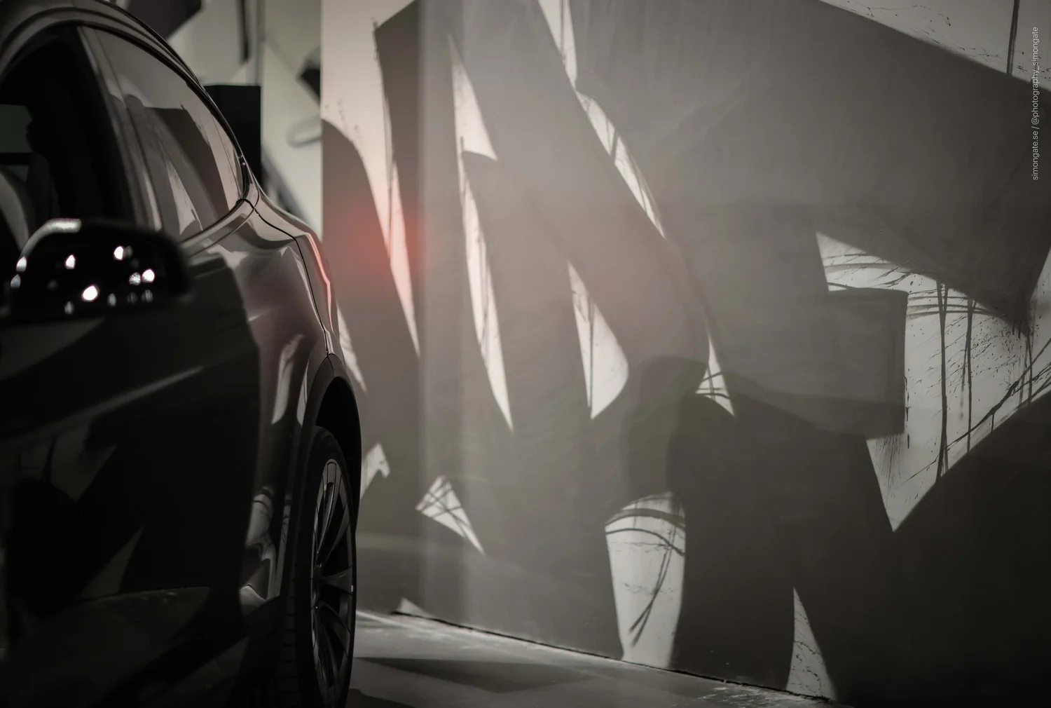 Close-up of a Tesla against the custom graffiti mural
