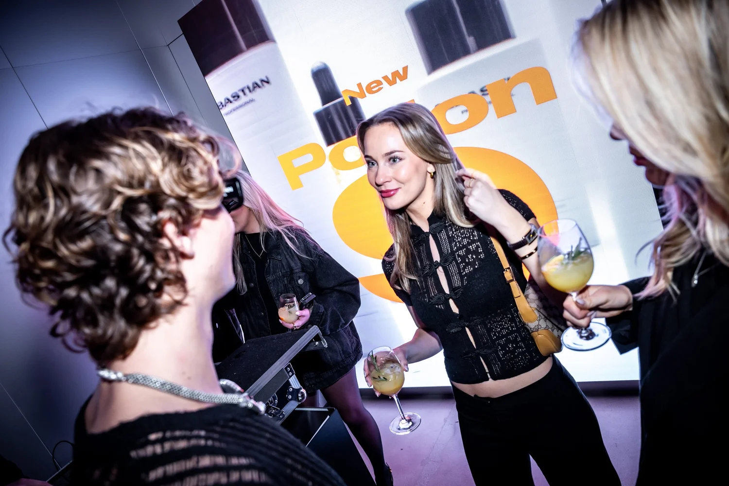 Guests toasting in front of the Potion 9 brand wall