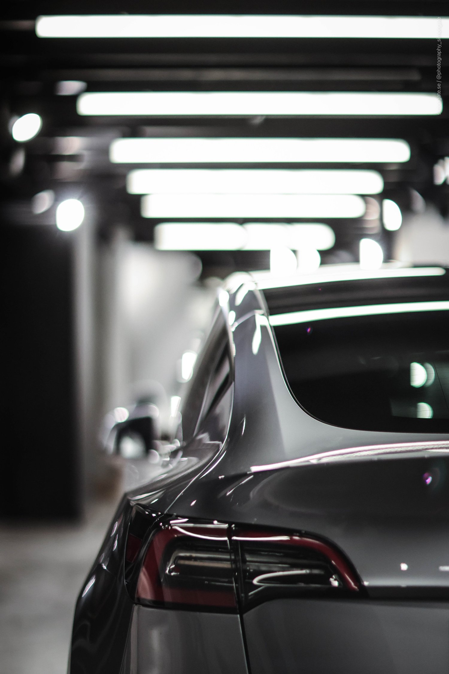 Rear of a Tesla under linear ceiling lights