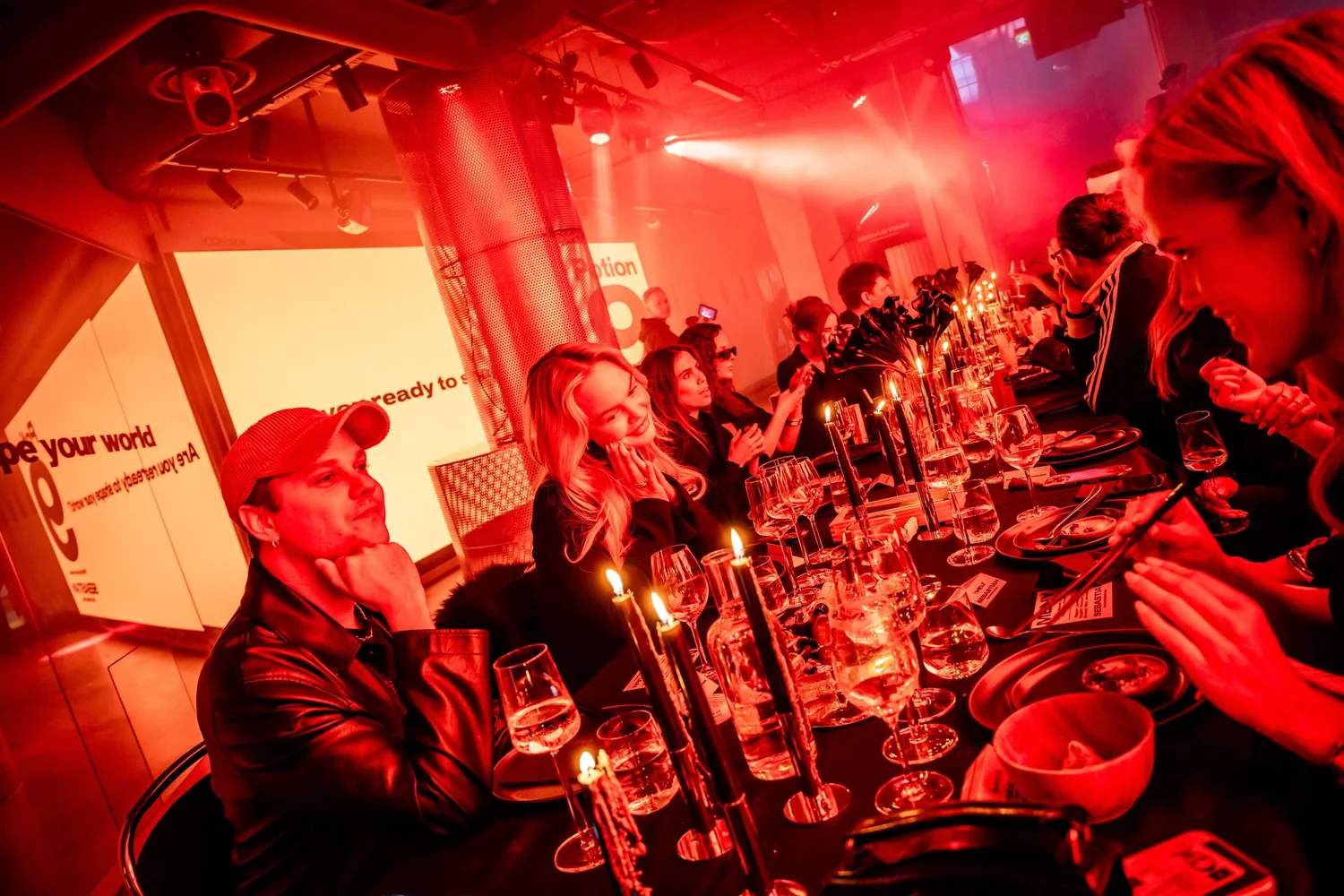 Guests seated at the long candlelit dinner table