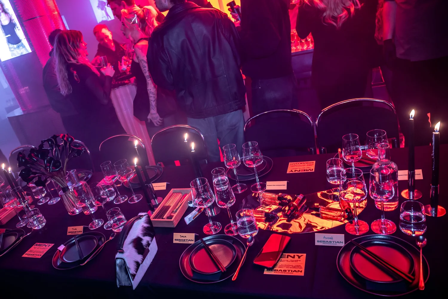 Dinner table set with candles and glassware in red light