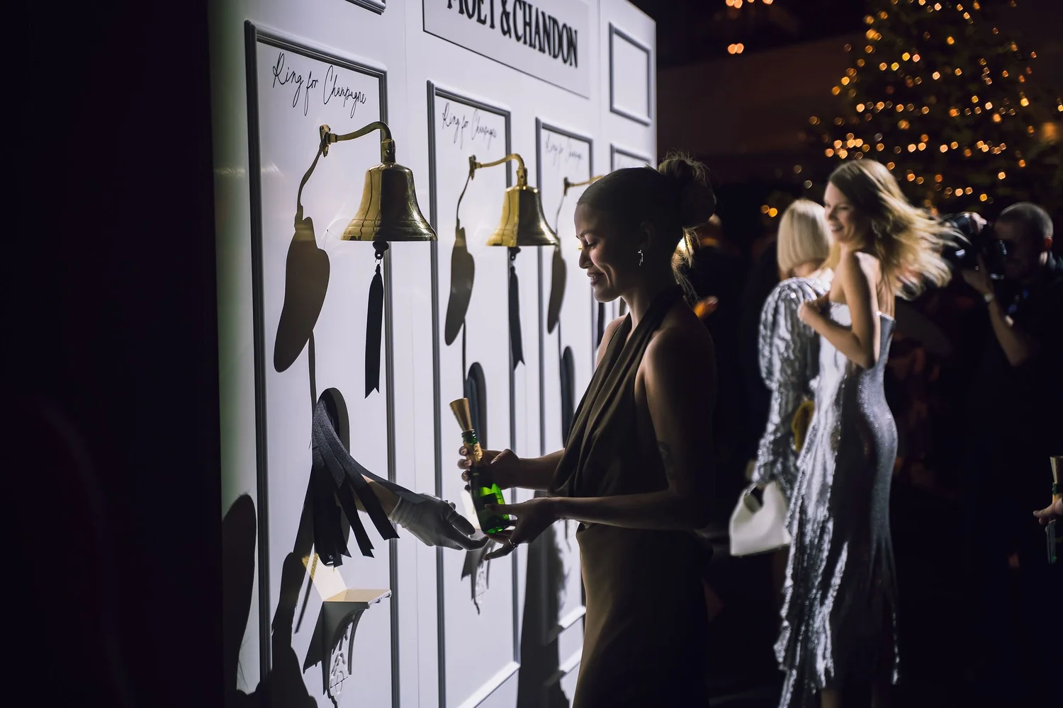 Guests at an interactive Moët & Chandon wall with brass bells