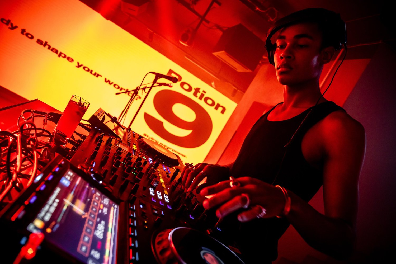 DJ performing in front of the Potion 9 backdrop