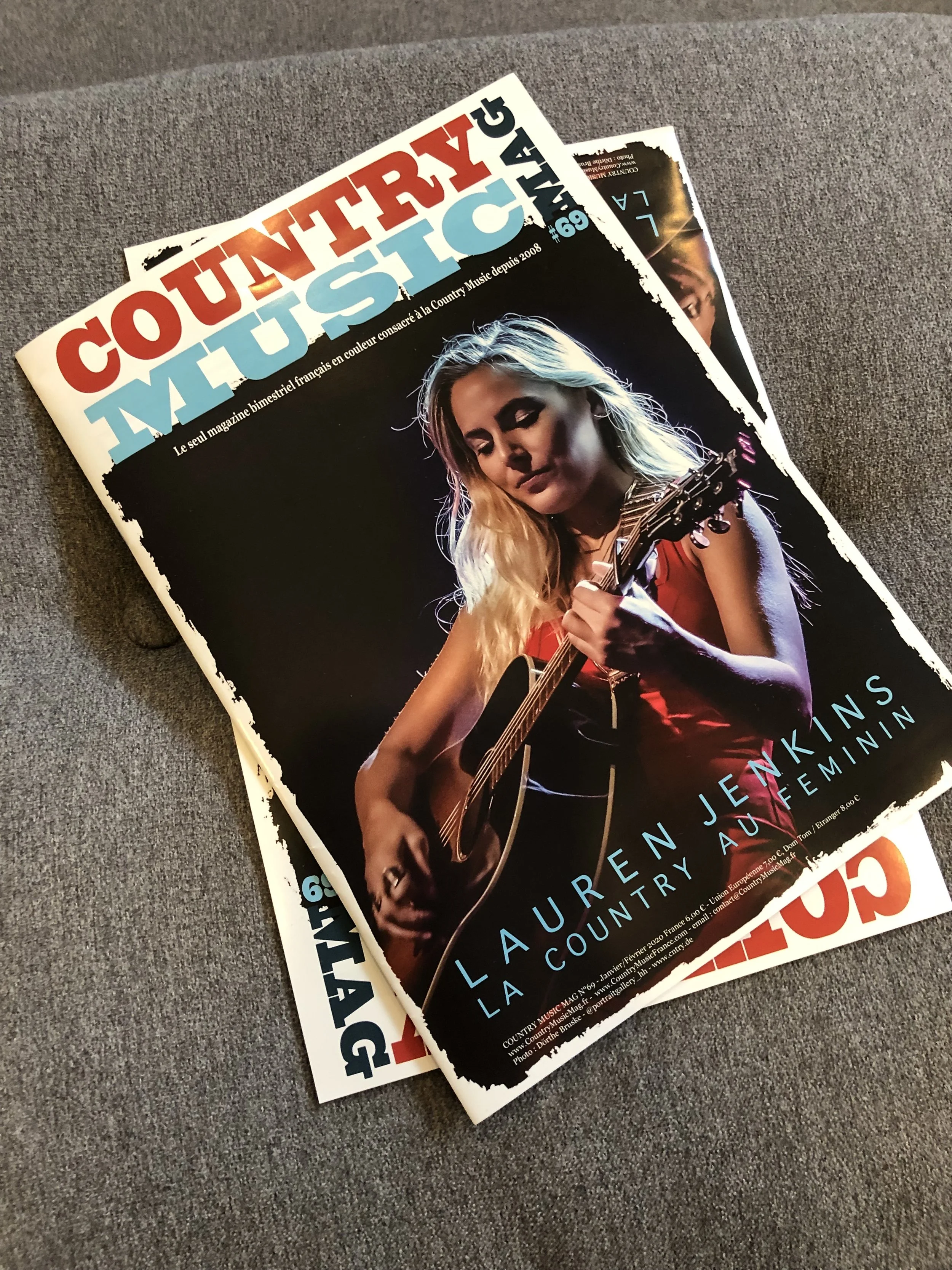 A magazine titled 'Country Music' featuring a young woman with long blonde hair playing an acoustic guitar on the cover, with the name 'Lauren Jenkins' and subtitle 'Country Auburn' visible.