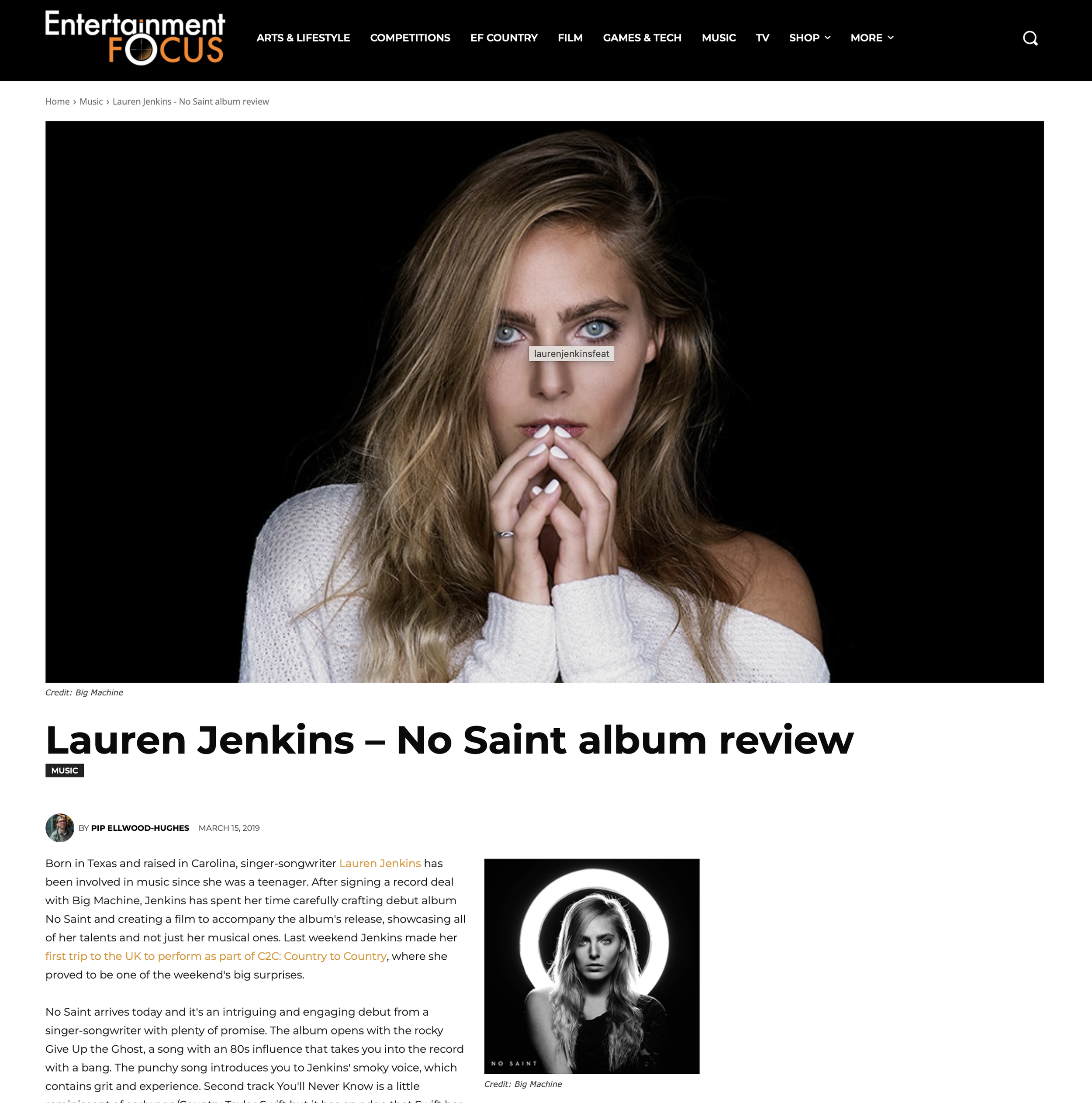 A portrait of Lauren Jenkins with long blonde hair, blue eyes, and a serious expression, wearing a white off-shoulder sweater and holding her hands near her face, against a black background.