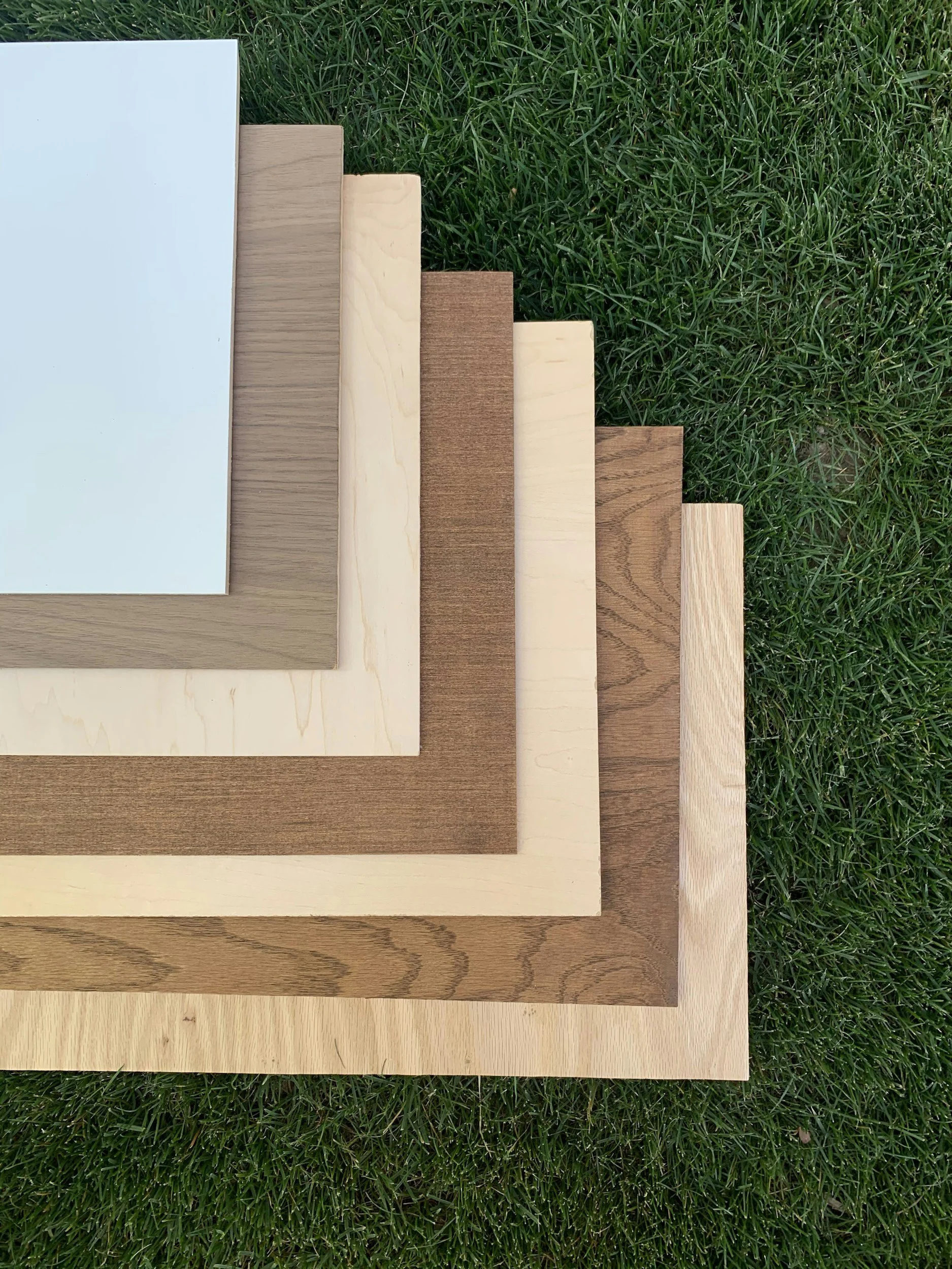 Stack of different wood veneer samples on grass