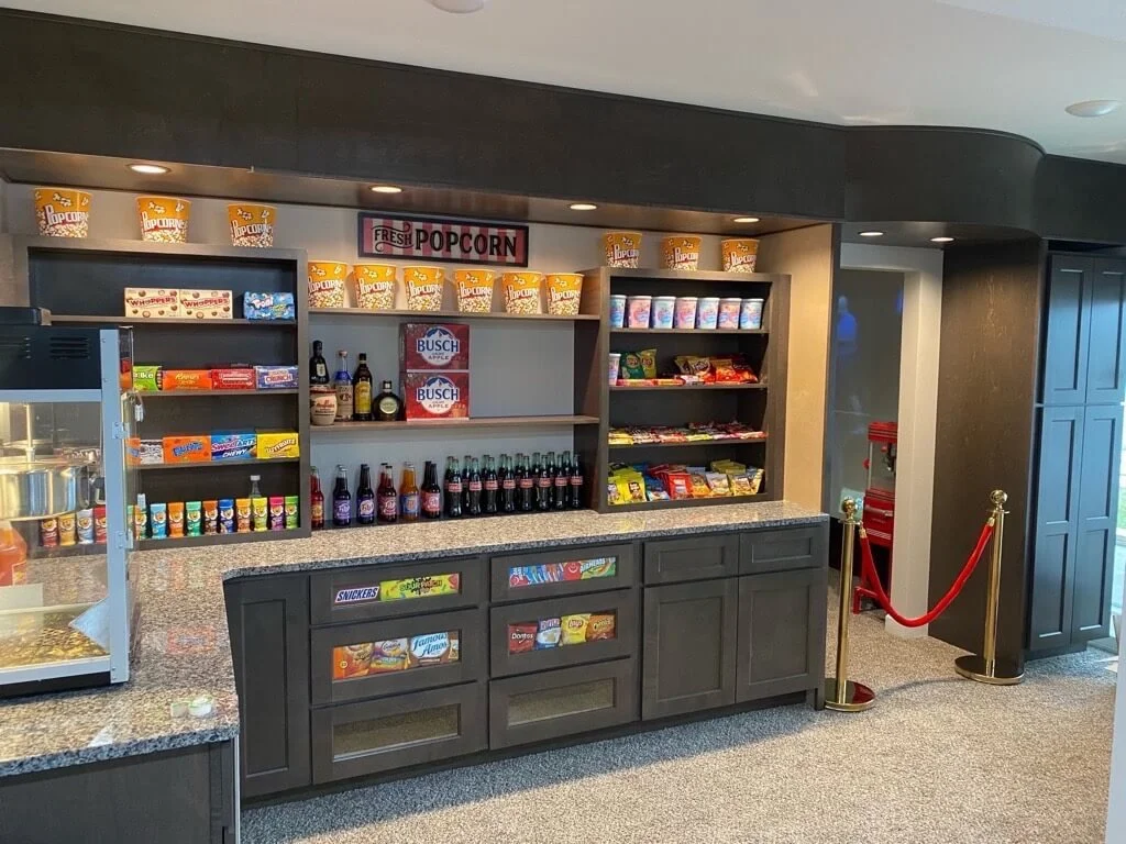 Home theater concession stand with popcorn, candy, and drinks