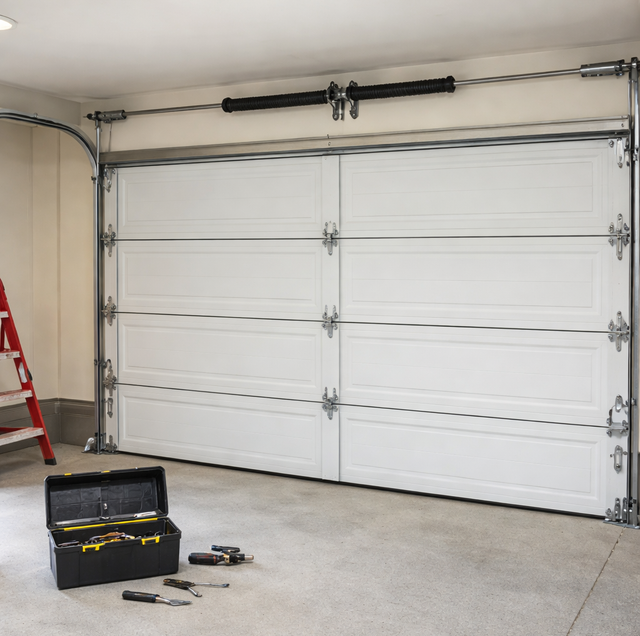 homeowner inspecting residential garage door springs and rollers