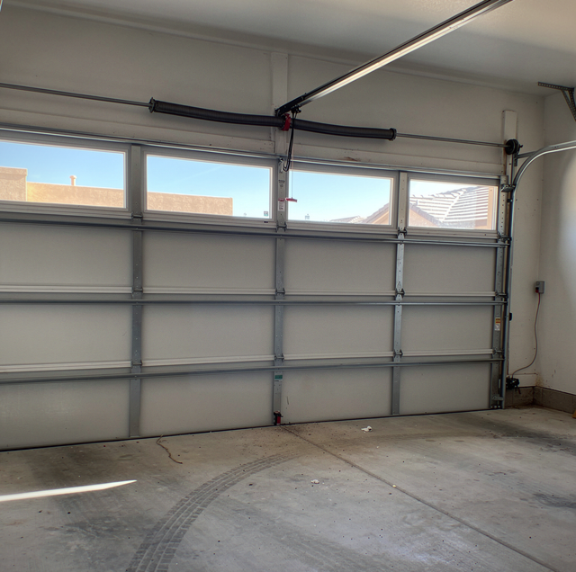 two steel torsion springs mounted above garage door