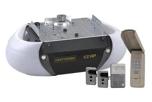 A robotic vacuum cleaner with a metal component on top, along with a remote control and two smaller remote devices, and a larger wall-mounted remote control.