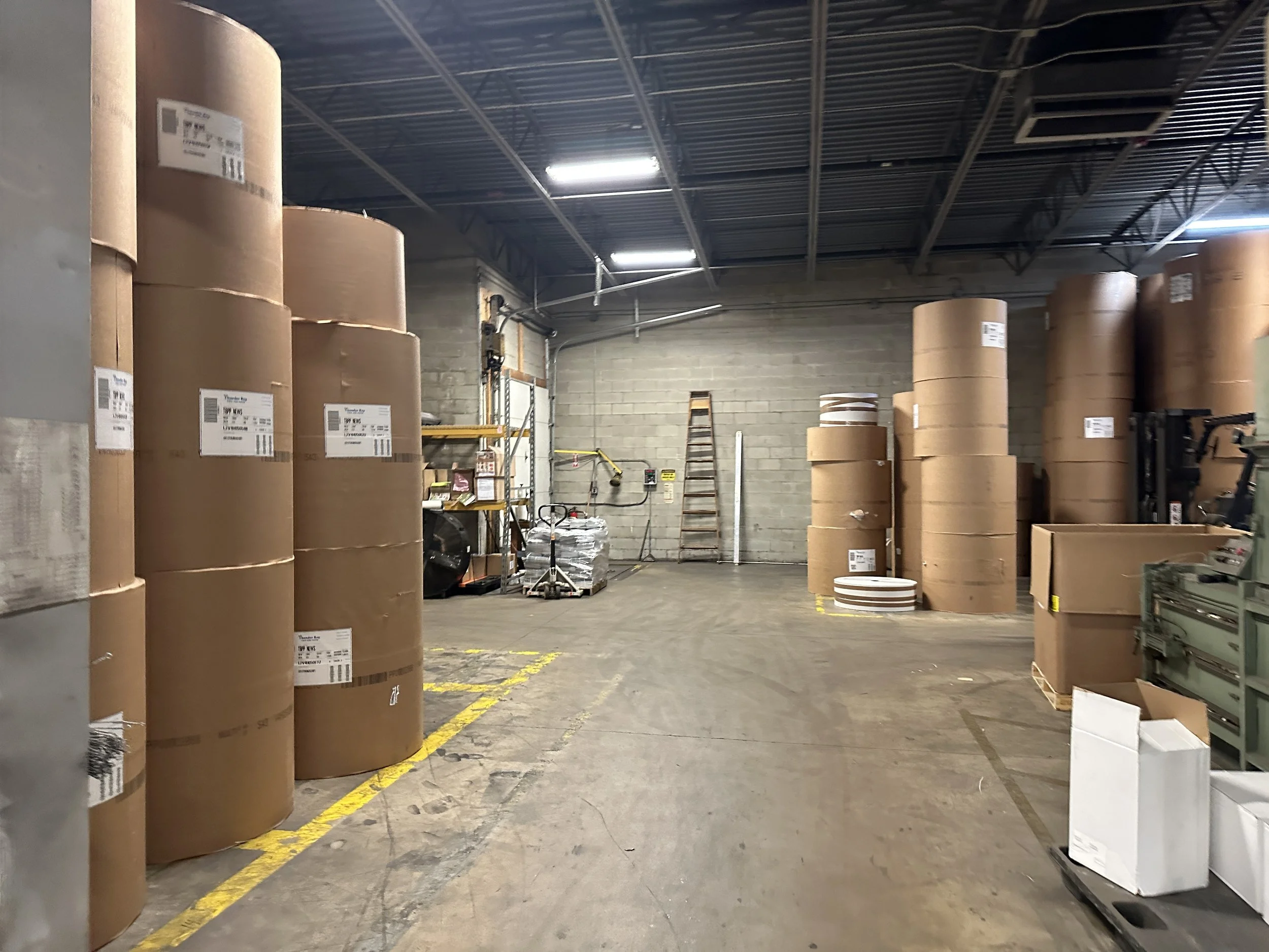 Massive storage drums of paper rolls for the presses