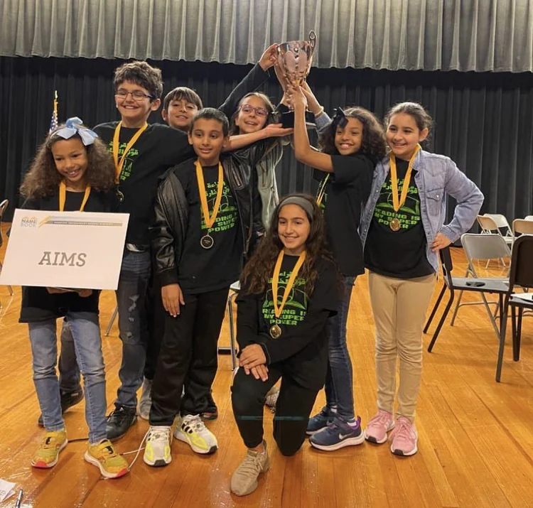 Students holding a trophy on stage