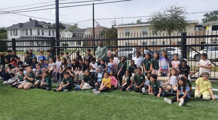 Children and two adults on a grassy field