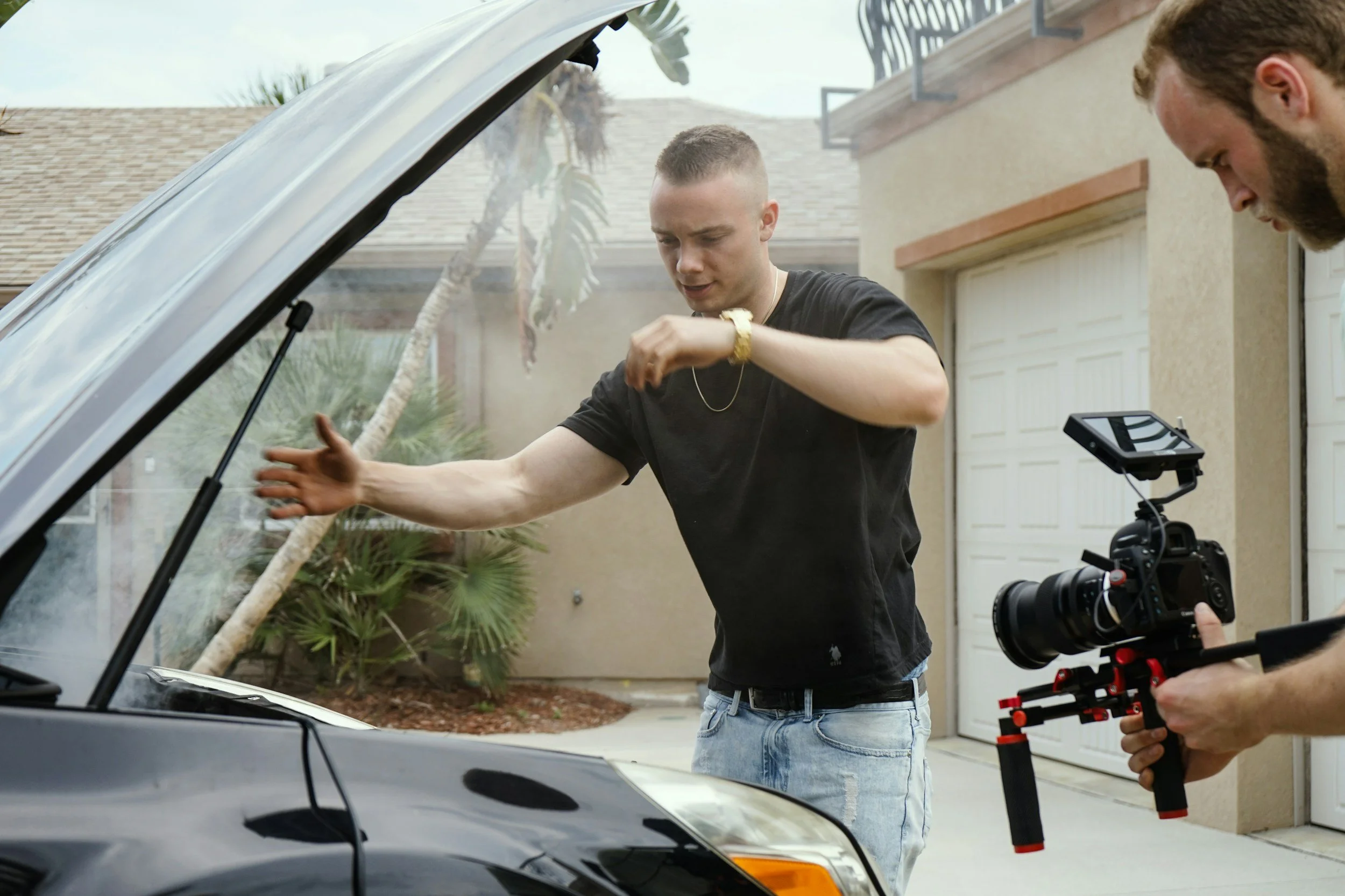 Behind the scenes filming a presenter beside a car with a cinema camera