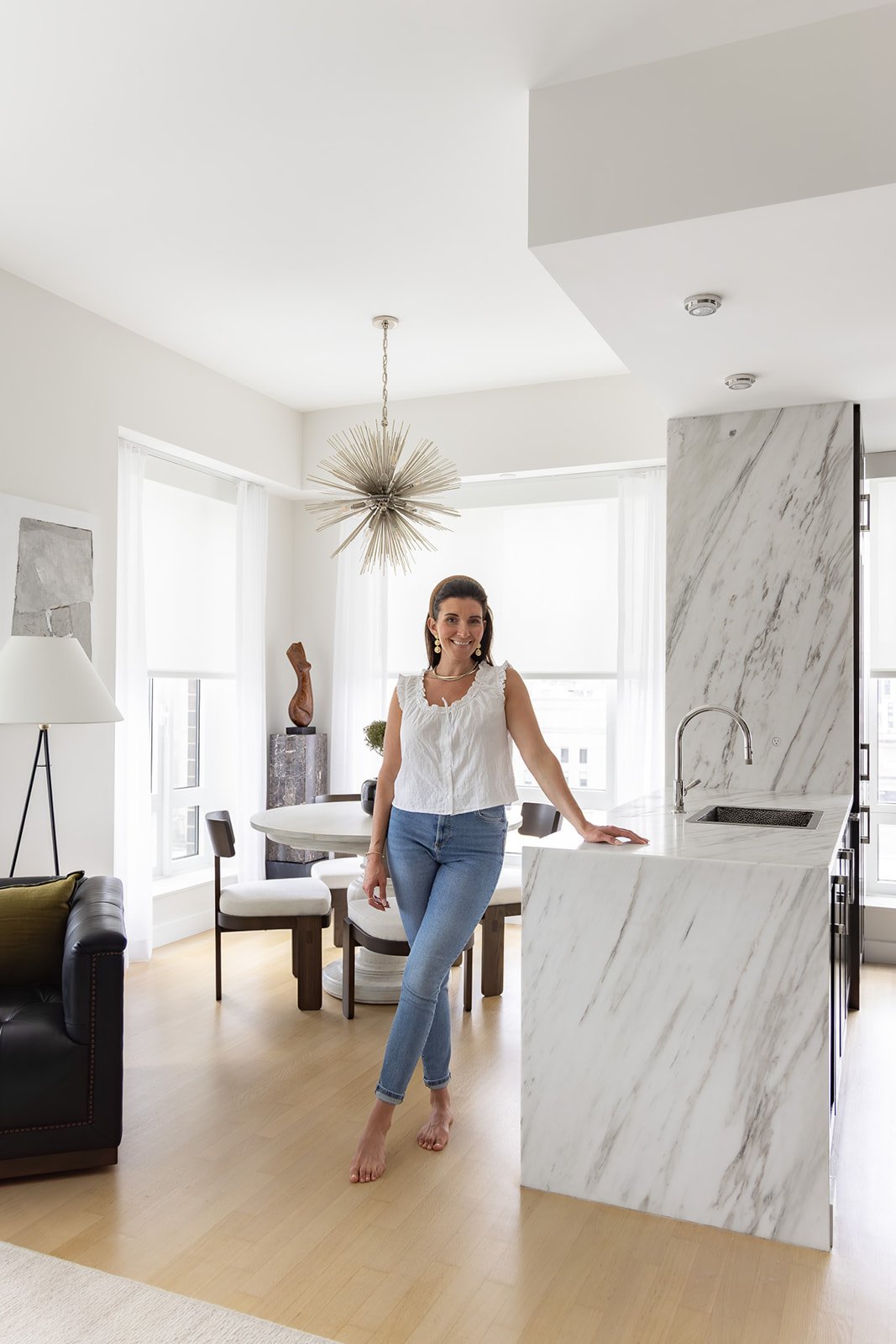 Brianna standing in a client's kitchen after a successful design and remodel project.