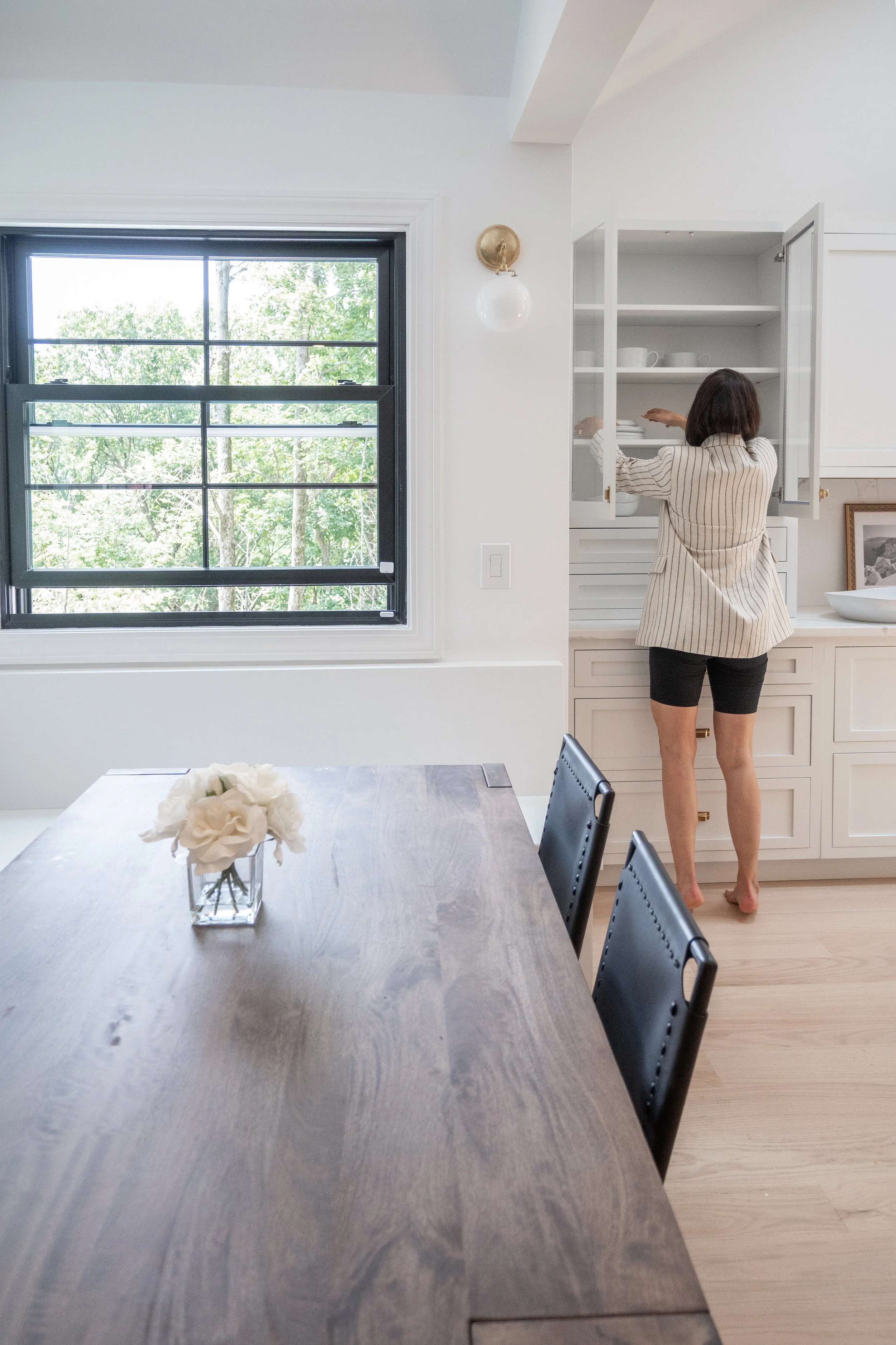 Florida and Boston interior designer meticulously organizing plates in a beautiful Leominster, MA kitchen