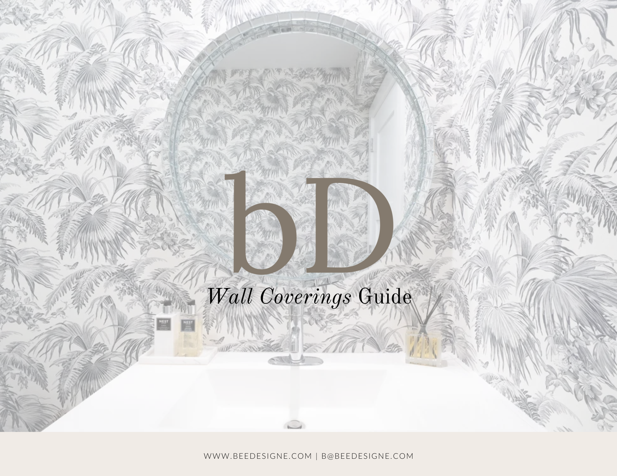 A bathroom with black and white tropical plant wallpaper, a round mirror, a white countertop with bottles, a faucet, and a small glass container with gold stripes.