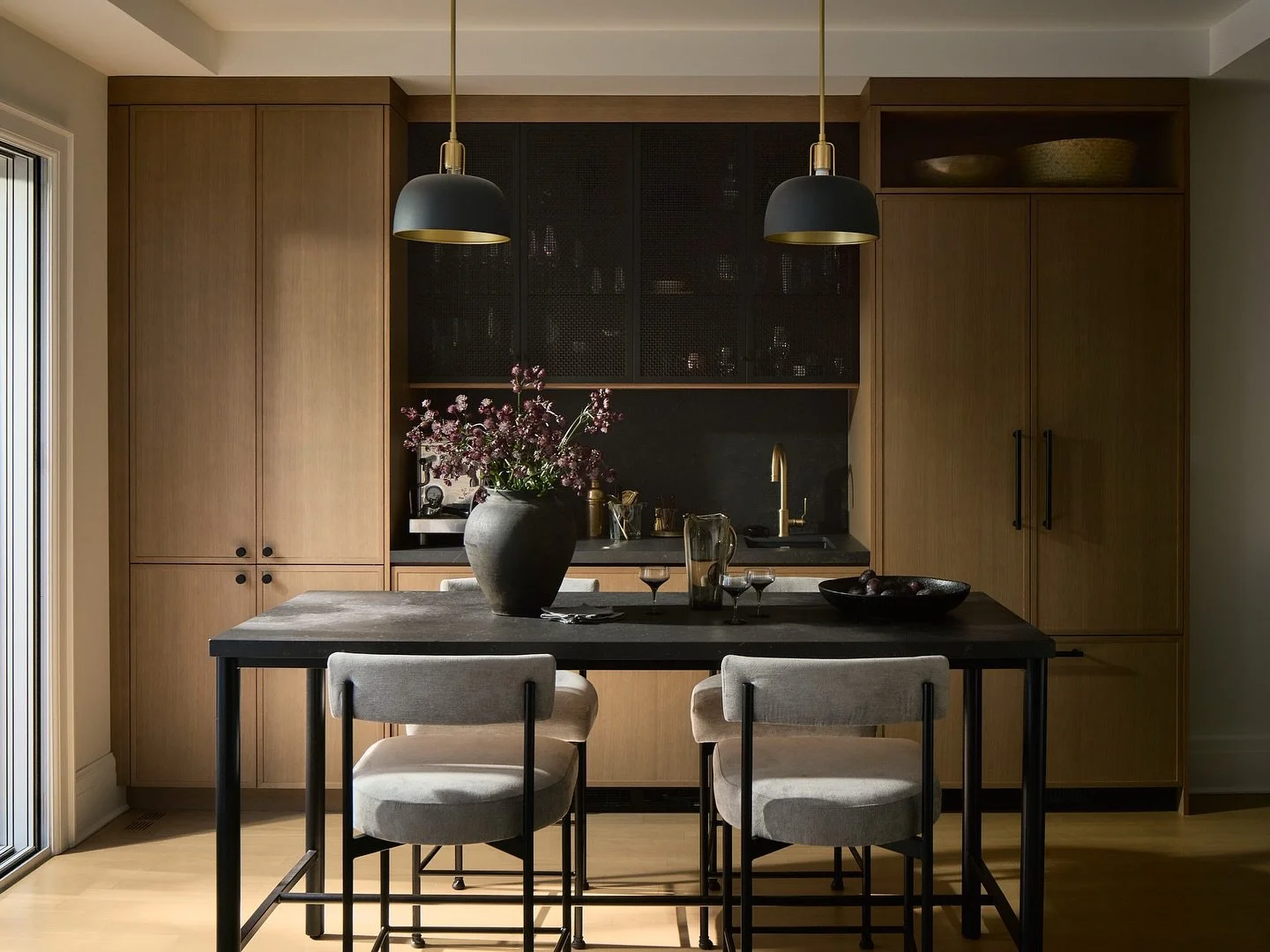 White oak veneered cabinets are dressing up this wet bar area designed by @designstrom and supplied by us! Right talls hiding the fridge and left side hiding pantry storage. Black details includes not only the Dekton stone surfaces and custom made is