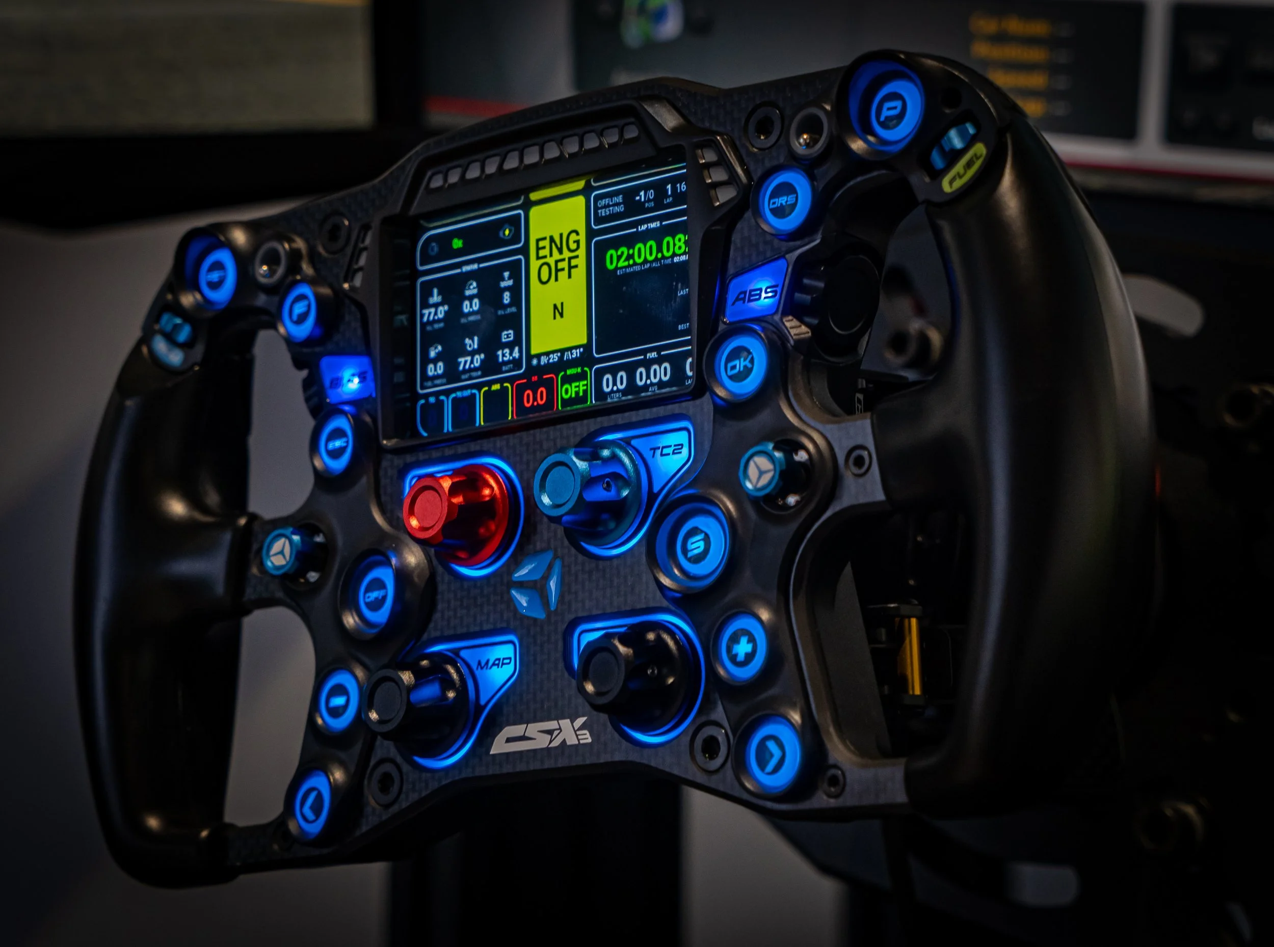 Raceauto stuur met verschillende knoppen, digitale displays en knoppen, verlicht in blauw en rood.