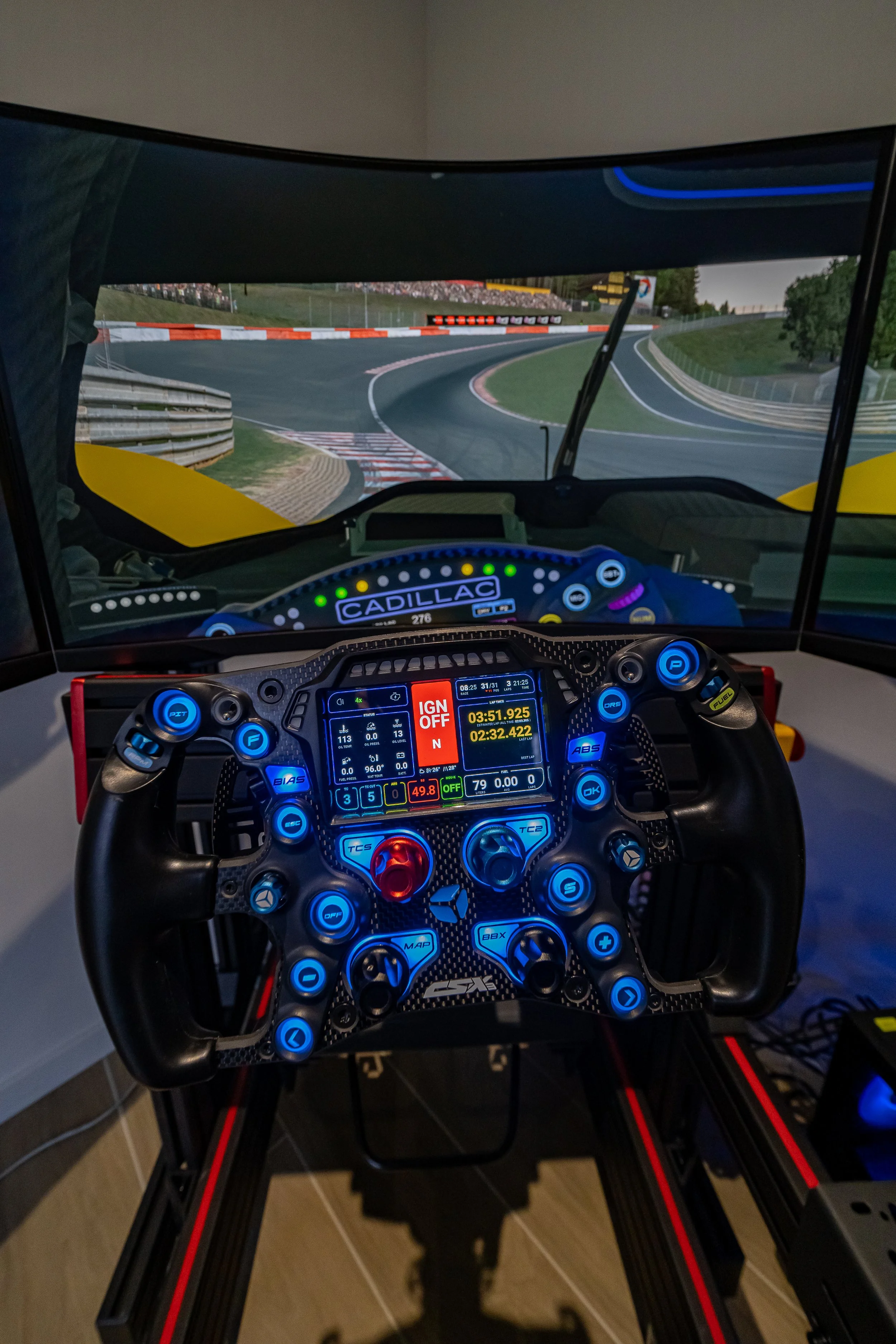 Racing simulator met stuurwiel en scherm die een autosnelweg op een circuit navigeert.