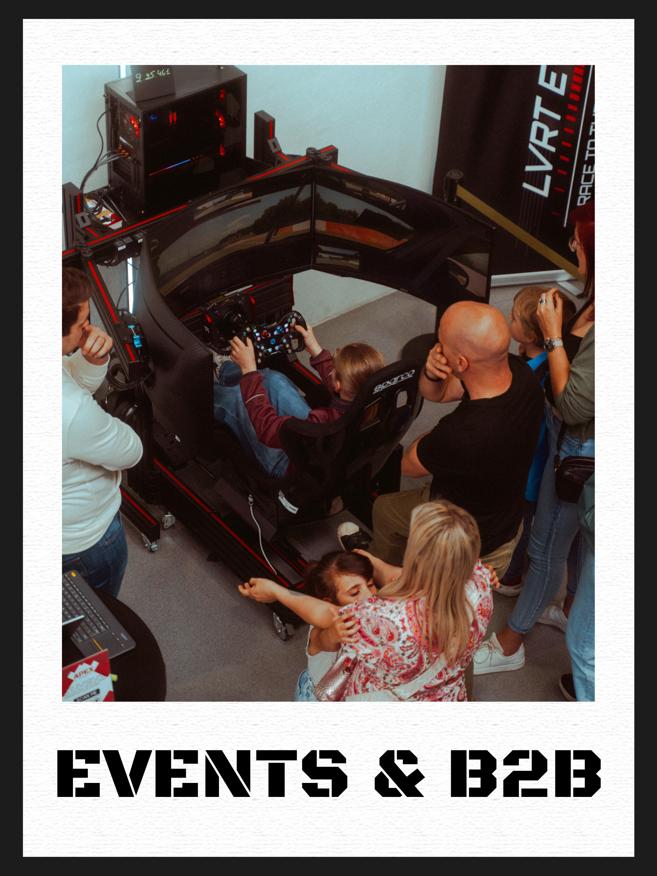 Een groep mensen rondom een racewagen simulatie, die gebruik maken van een simulatietoestel met drie schermen en een raceautoradio. Er zitten kinderen en volwassenen in de scene.