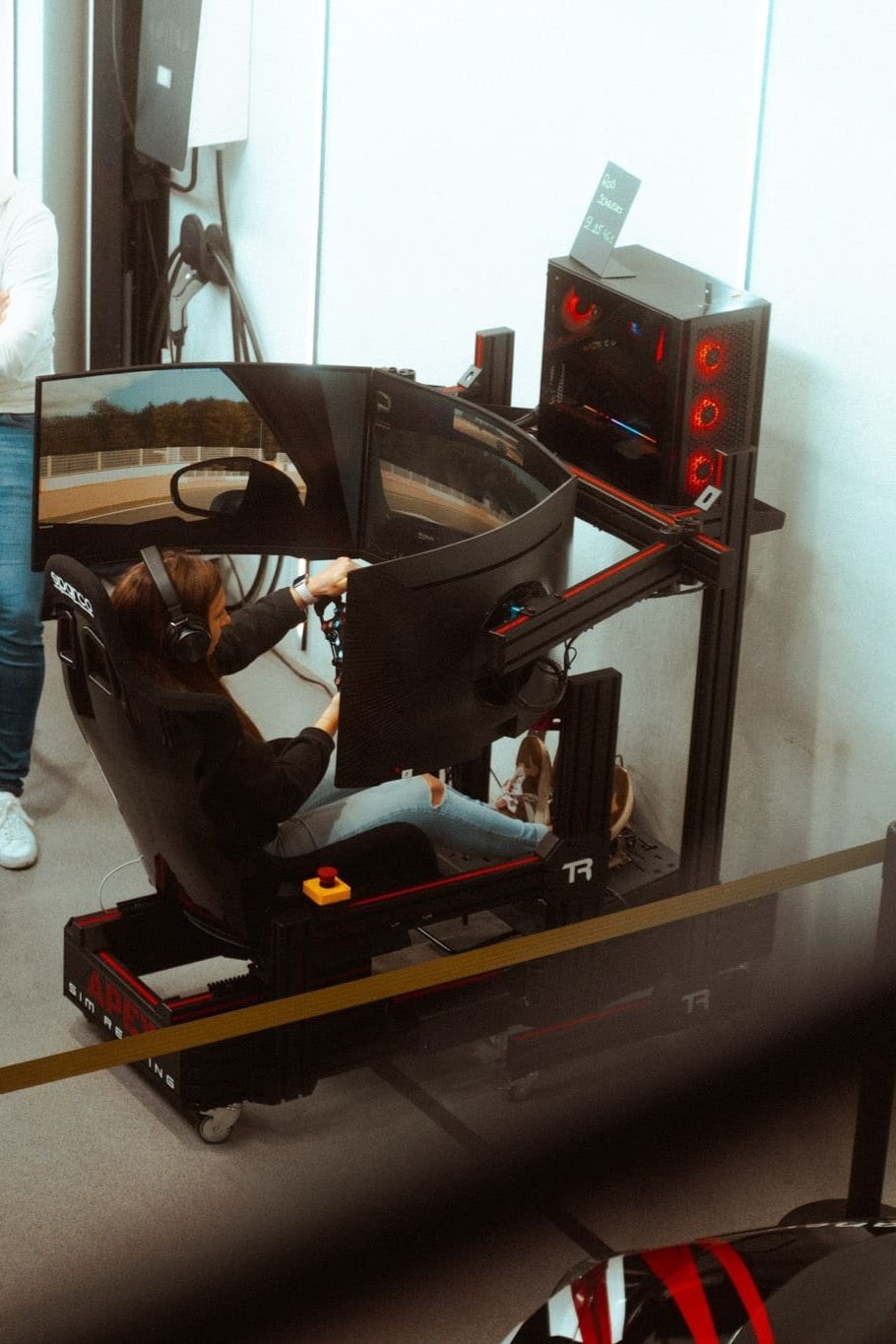 Een jonge dame die gebruikt maar van onze race simulator die gehuurd werd voor een evenement.