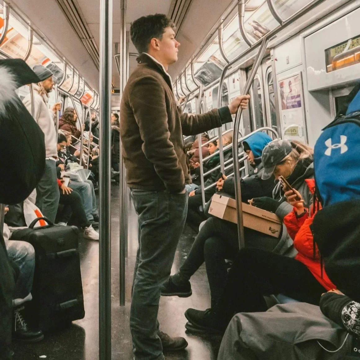Crowded subway car with standing and seated passengers during transit