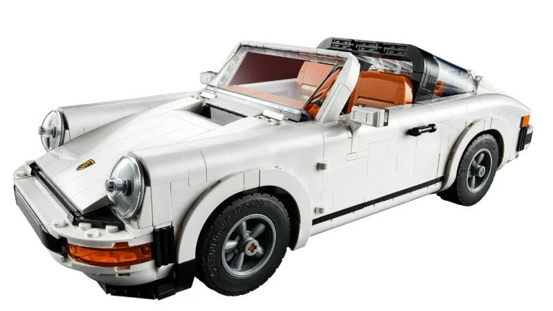 Lego model of a vintage white Porsche convertible car with orange interior and black tires.