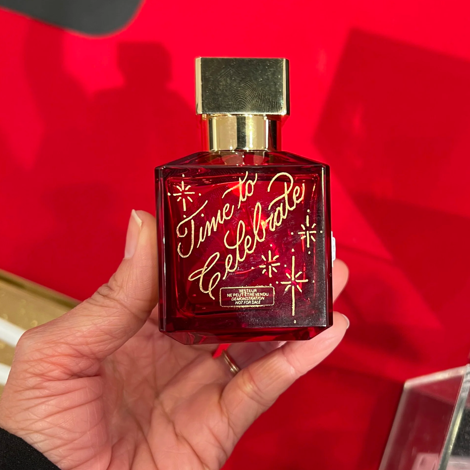 red perfume bottle with gold engraving that says "Time to Celebrate"