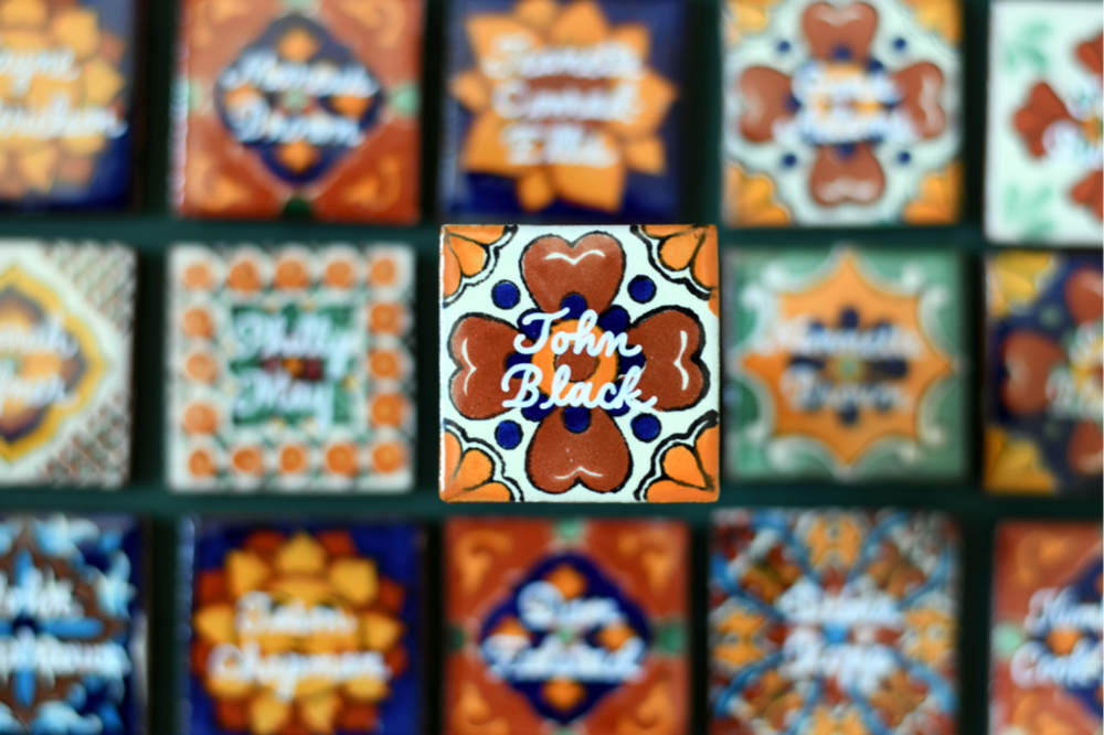 Custom Mexican Azulejo tile place cards with gold hand-lettered calligraphy for a luxury team corporate event