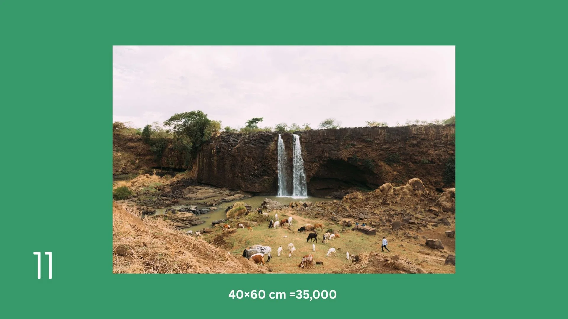 A landscape featuring a waterfall flowing from a cliff with trees on top. Below, there are goats grazing on a grassy area near rocks, with a few people walking around.