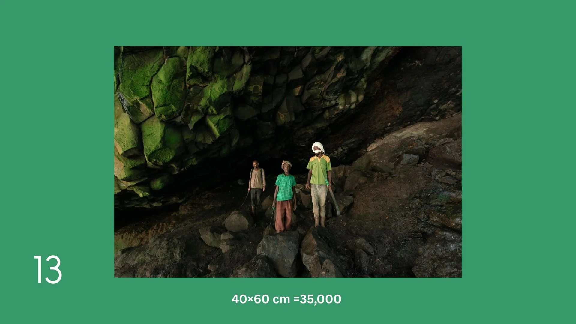 Three people exploring a dark, rocky cave with moss-covered rocks on the ceiling.