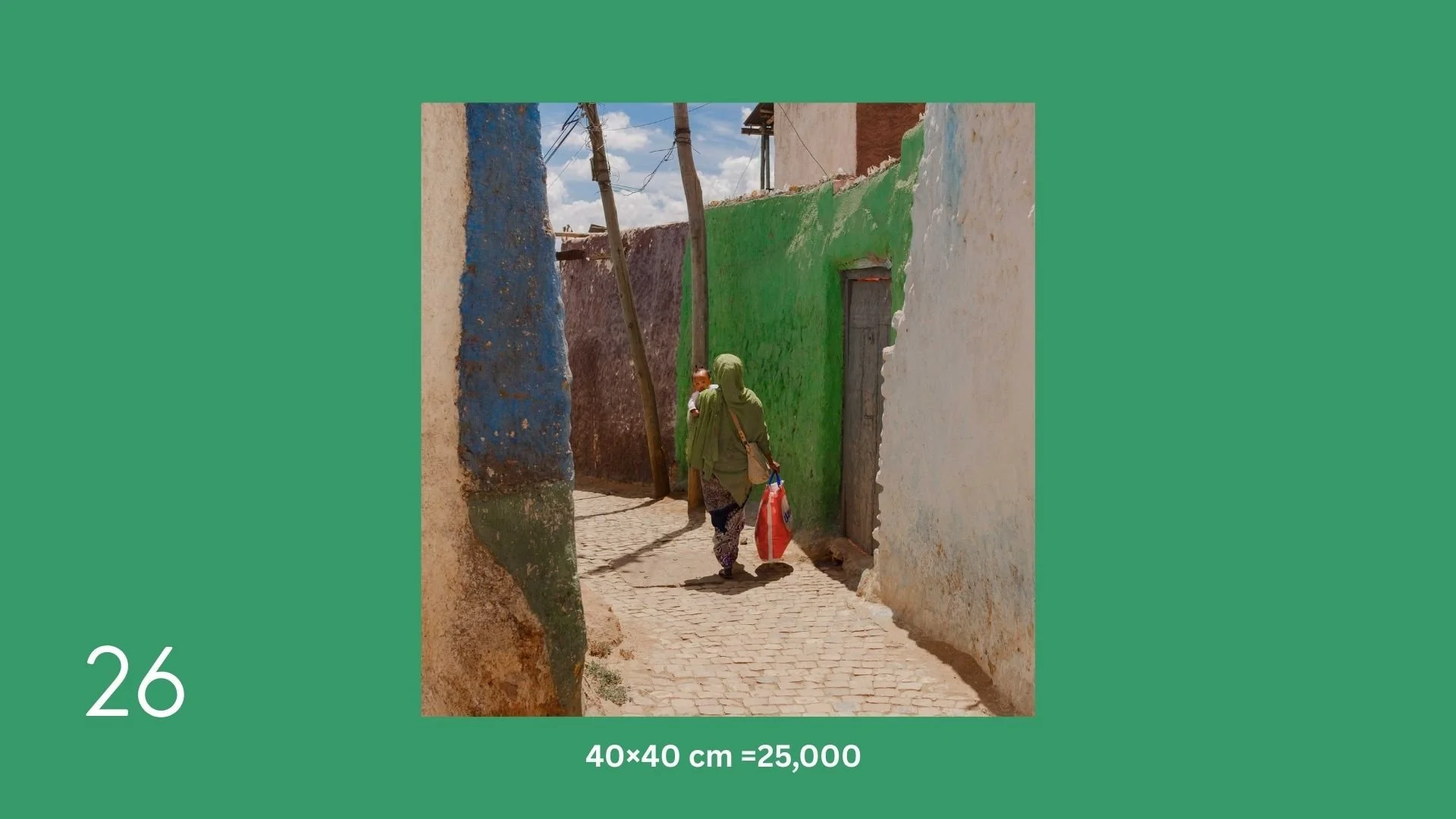 Woman wearing a green headscarf and green top walking with a child in an alleyway with colorful painted walls, carrying a red bag.