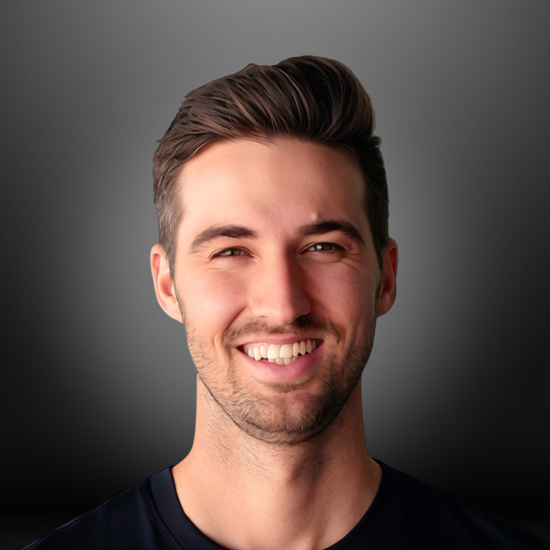 A smiling man with brown hair and a short beard, wearing a black shirt, against a gray background.