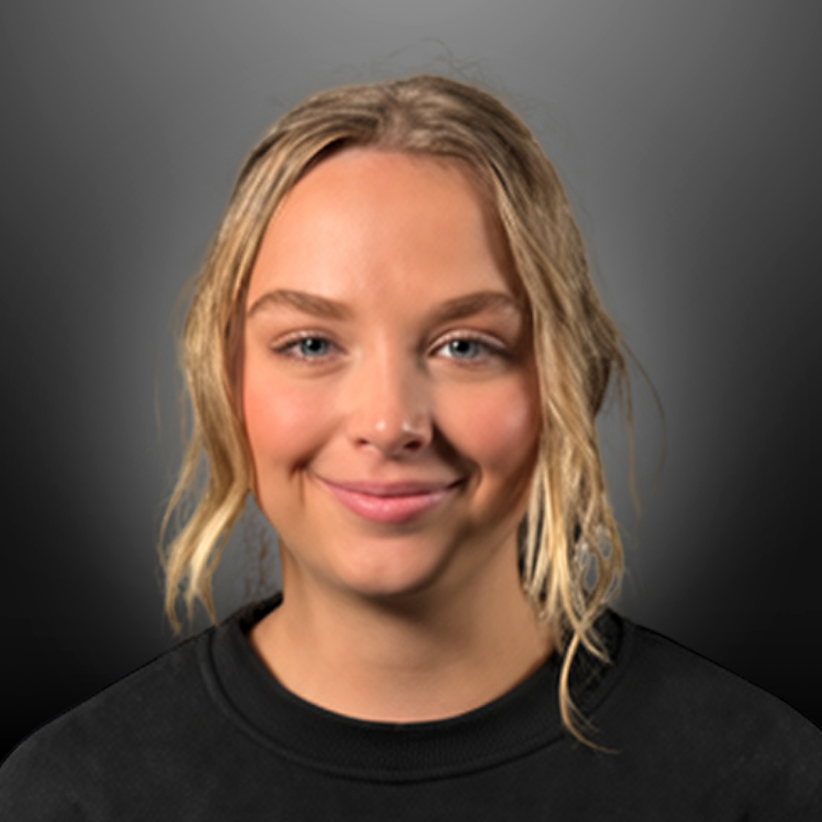 Smiling young woman with wavy blonde hair wearing a black top, against a dark gray background.