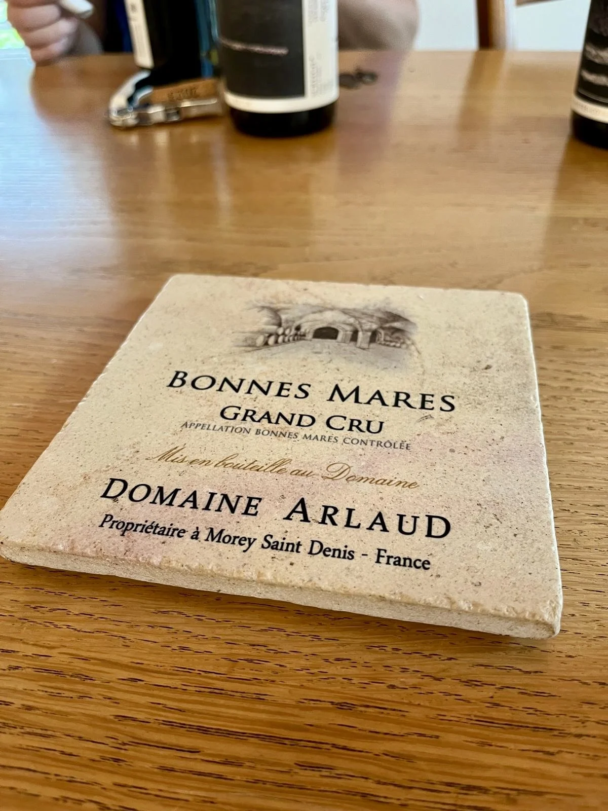 Étiquette de vin sur une surface en bois, indiquant Bonnes Mares, Grand Cru, Domaine Arlaud, Morey Saint Denis, France.