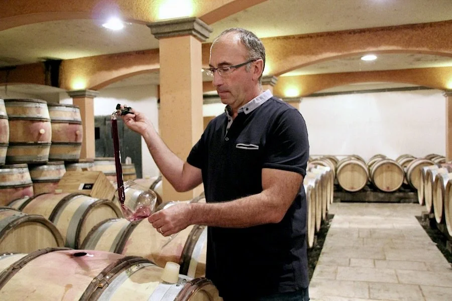 Jean Pierre Guyon qui soutire du vin dans sa cave