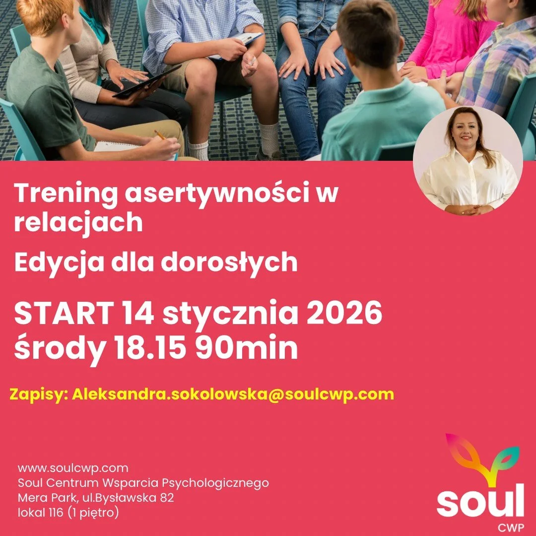 Group of people participating in a discussion or workshop, sitting in a circle in a room with patterned carpet.