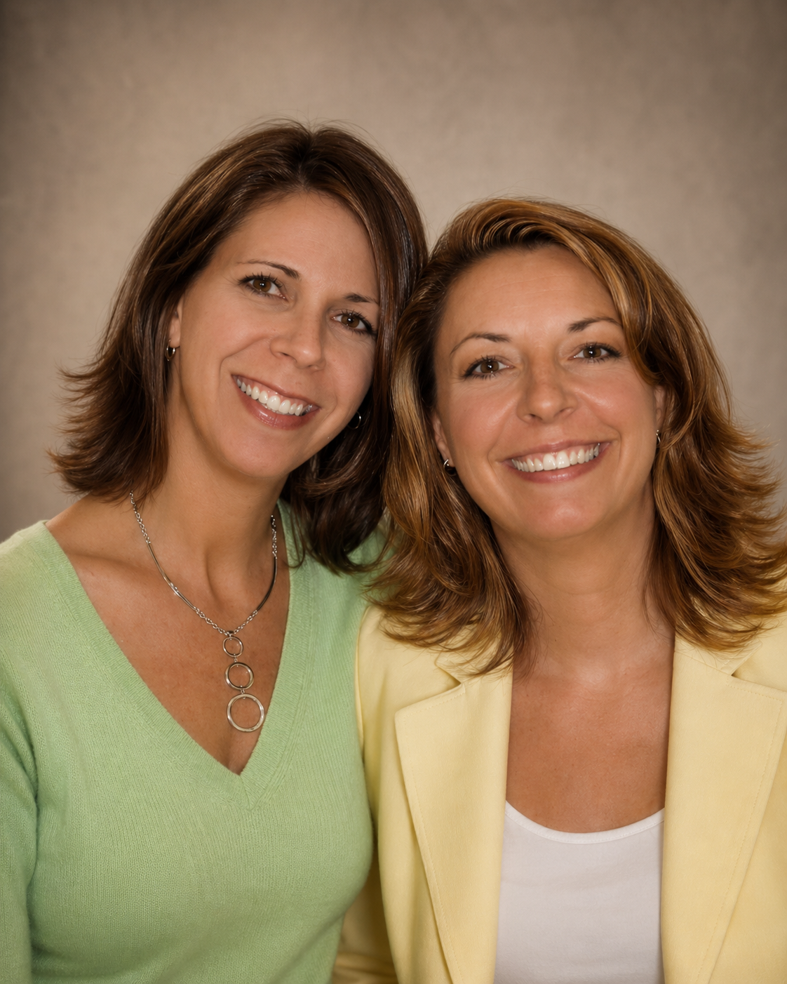 Two smiling women posing together in a professional portrait, representing the personal story, family inspiration, and heartfelt roots behind Pineapple Picasso in Cape Coral, Florida.