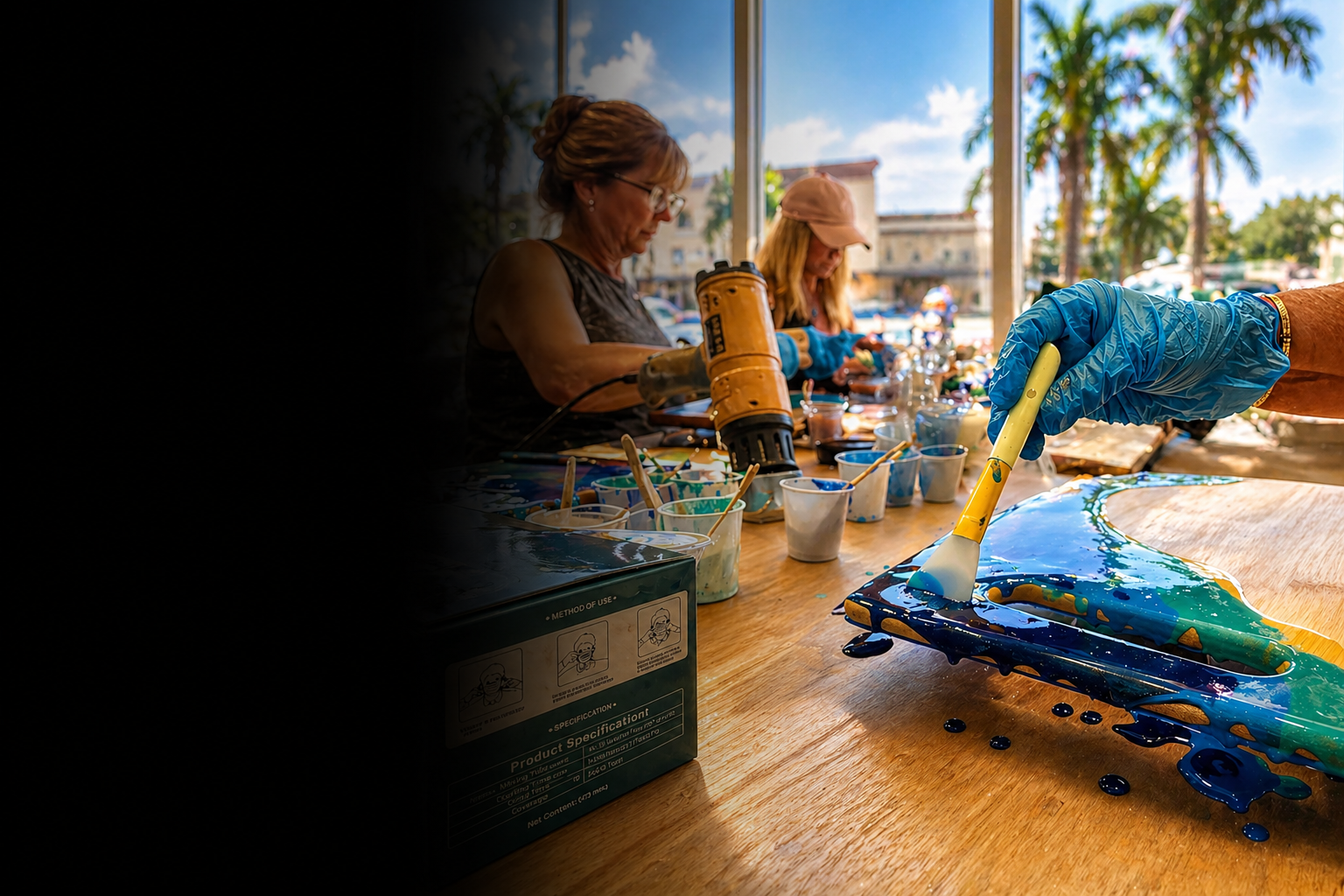 Gloved hand brushing blue resin onto wood during a creative art class