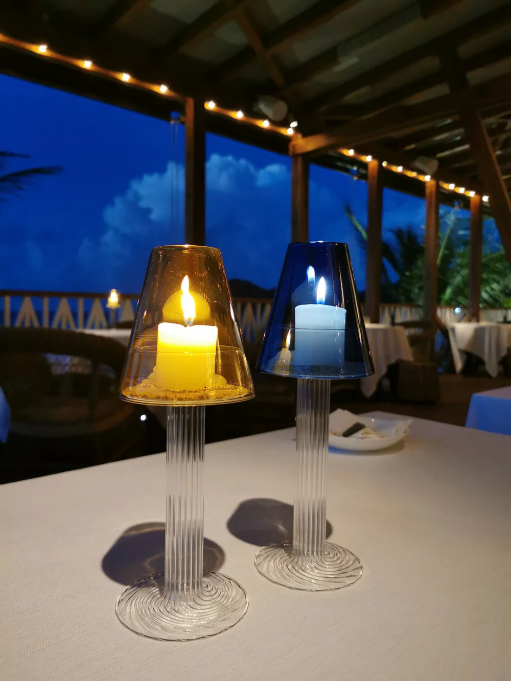 A Casarialto candleholder lit at night on a restaurant terrace