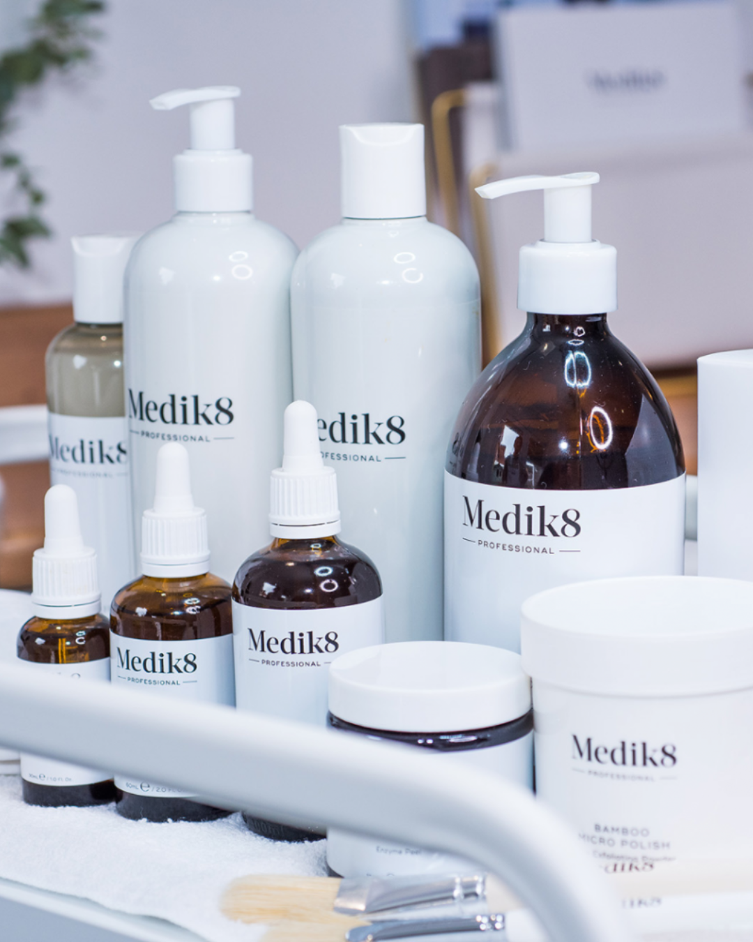 Collection of Medik8 skincare products including bottles, jars, and droppers on a white surface.